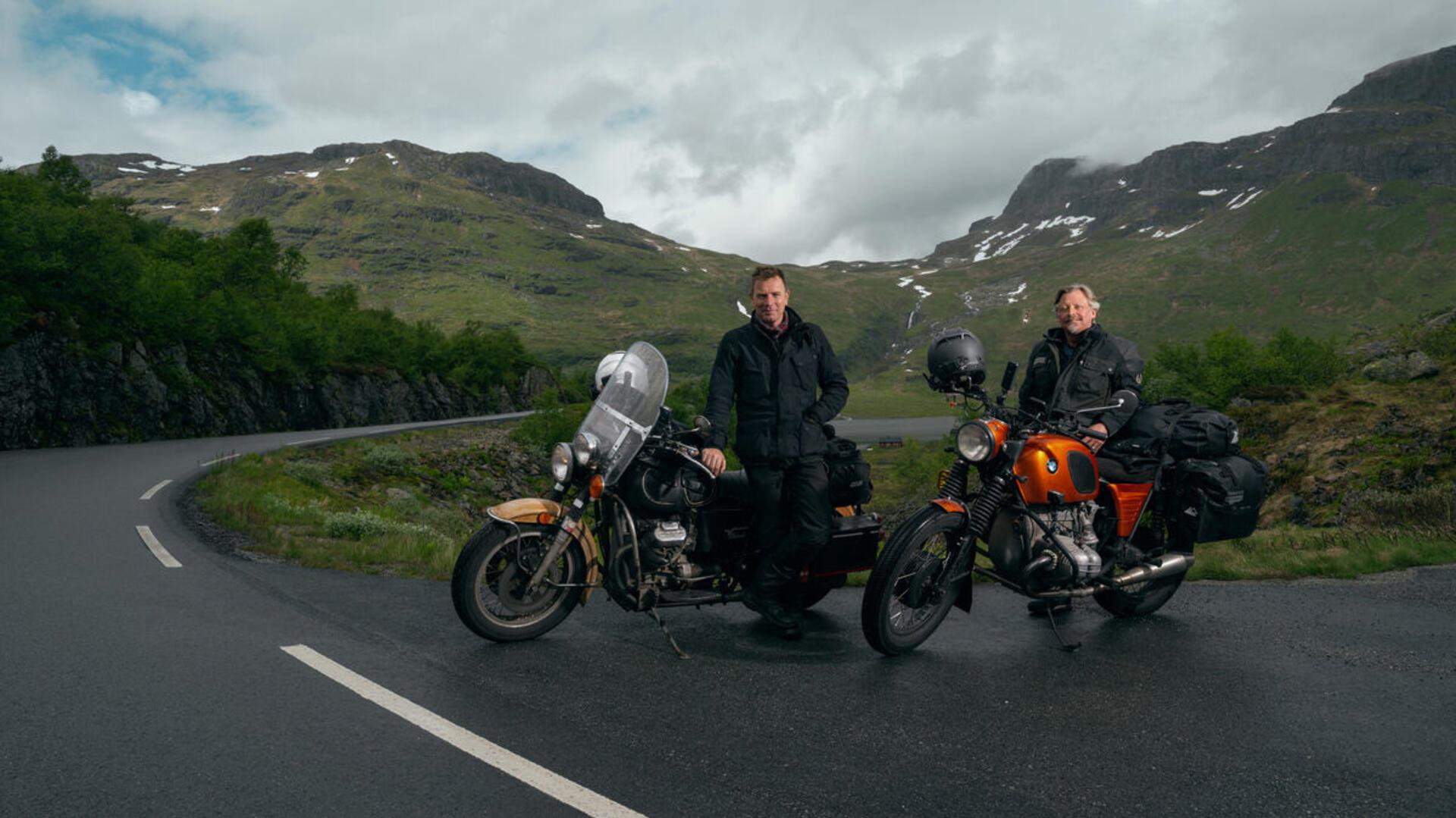 Ewan McGregor (links) und Charley Boorman mit ihren Motorrädern vor einer Landschaft. Auf ihrer Tour besuchten sie auch ein Schützenfest im Kreis Cuxhaven.