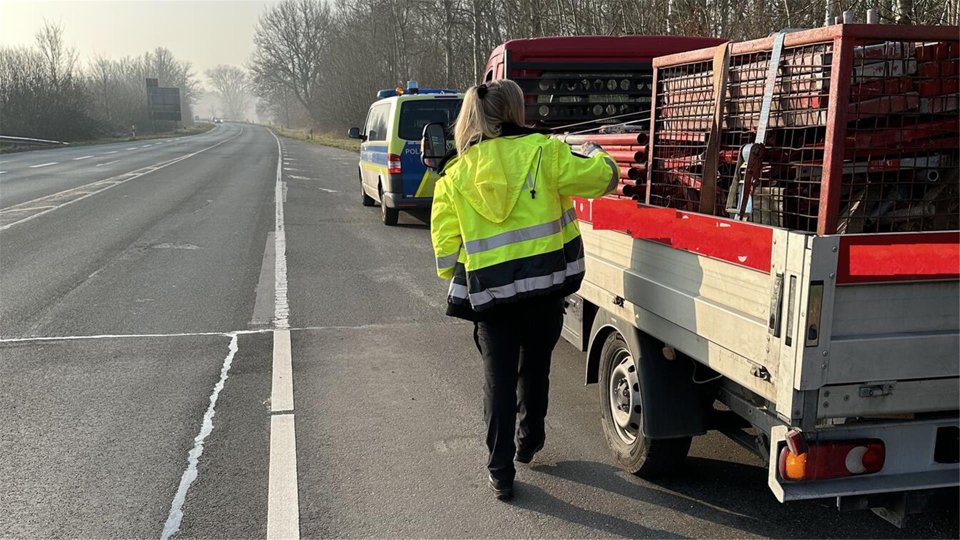 Eine Polizistin kontrolliert ein Fahrzeug während einer Verkehrskontrolle.