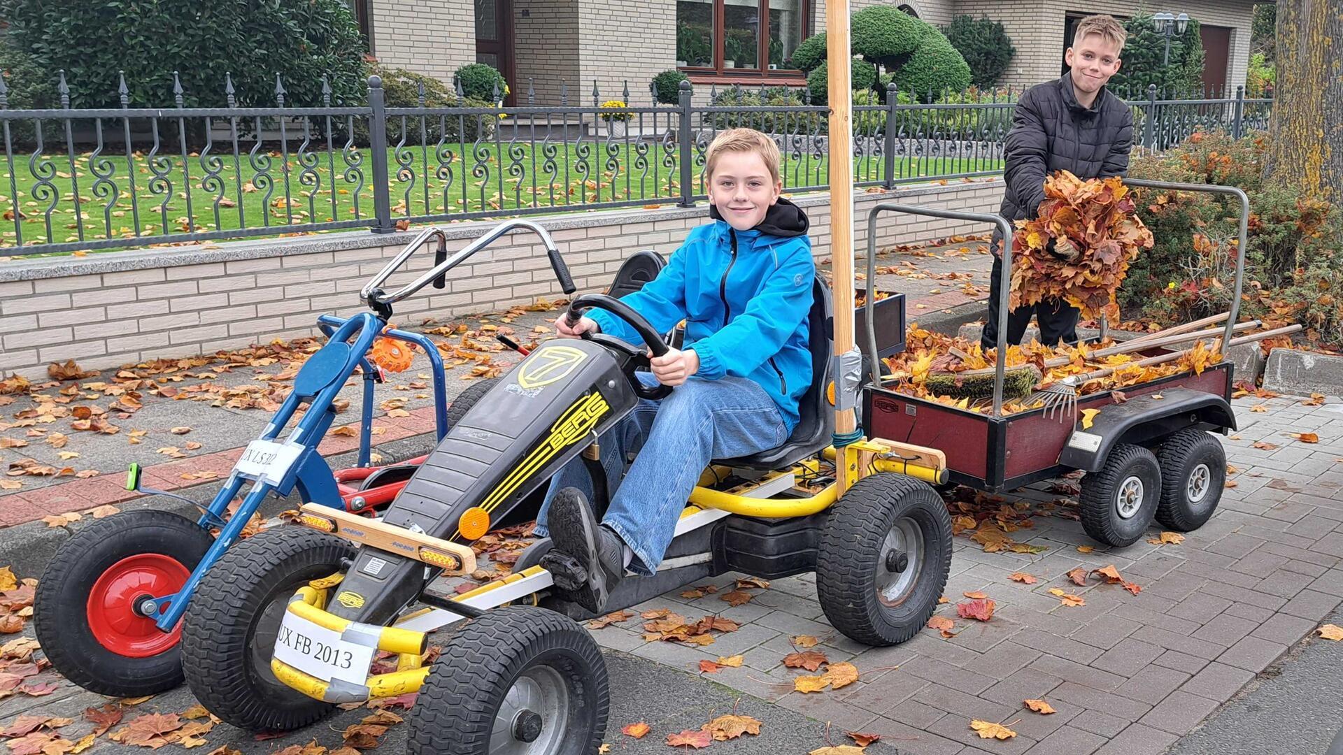 Felix und Liam kehren Laub in Bexhövede.