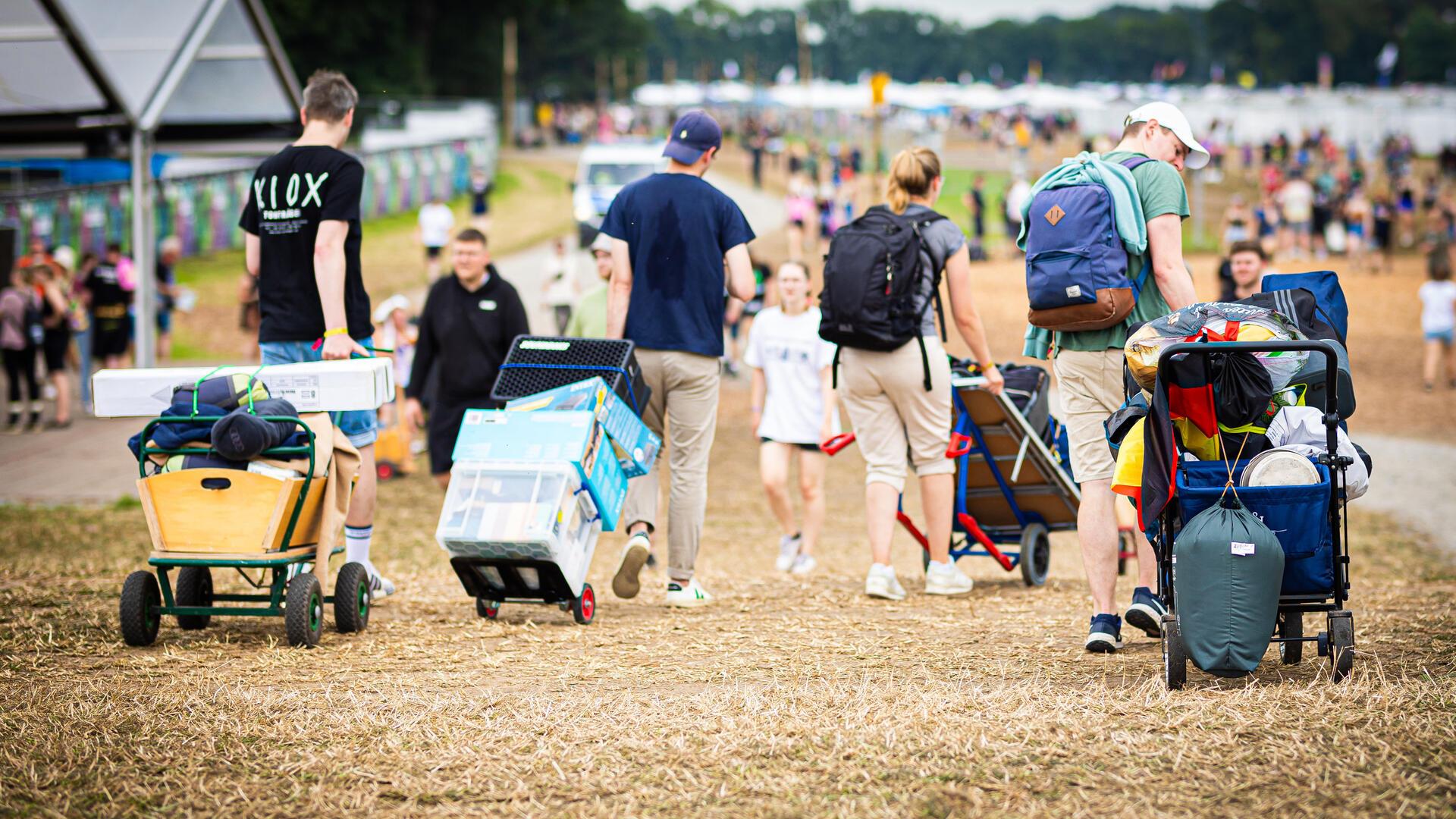 Erst Sonne, dann plötzlich Starkregen und Matsch: Der Hurricane-Freitag in Bildern Festivalbesucher kommen mit ihrem Gepäck am Zeltplatz des Hurricane Festivals an.