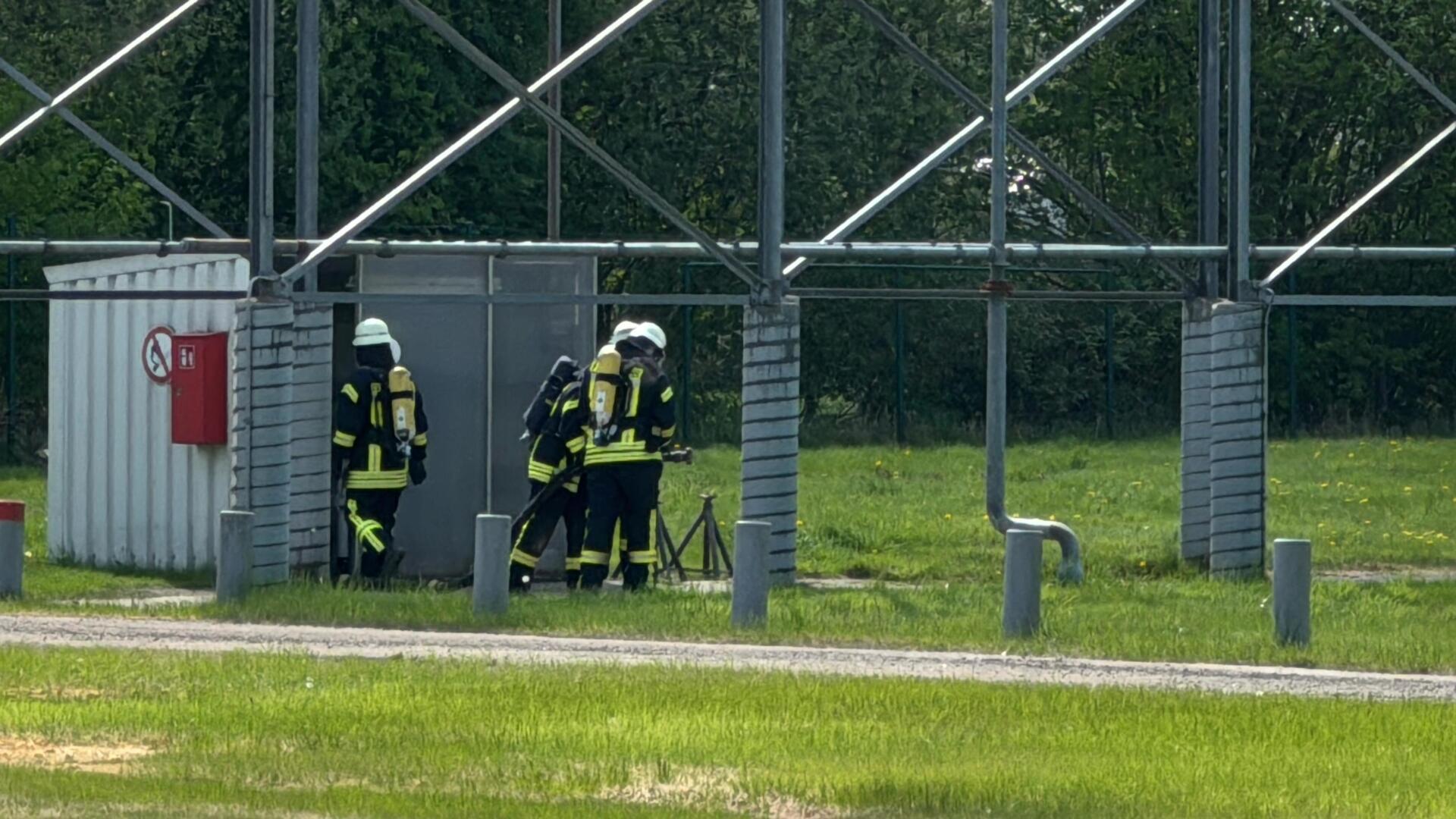 Feuerwehrleute unter Atemschutz nehmen Messungen an der Einsatzstelle vor.