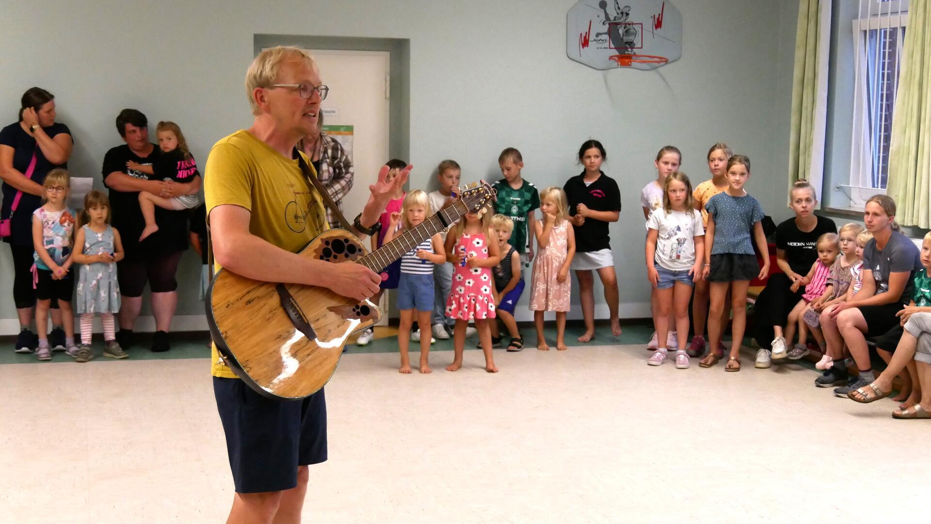 Florian Müller mit Kids aus dem Ort bei der Uraufführung des Songs "Hepster Kinder" im August diesen Jahres im Hepsteder Dorfgemeinschaftshaus.
