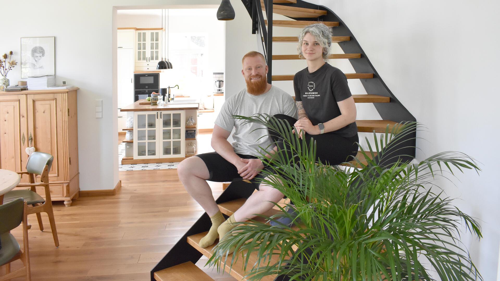 Ein Mann und eine Frau sitzen auf einer Treppe.