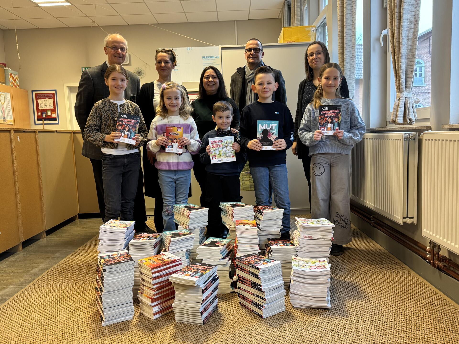 Freude über die Bücherberge: Rotary Club-Präsident Joachim Pahl (hinten links) übergibt den Lesestoff zu gern an Schülerinnen und Schüler der Altwulsdorfer Schule und der Veernschule.