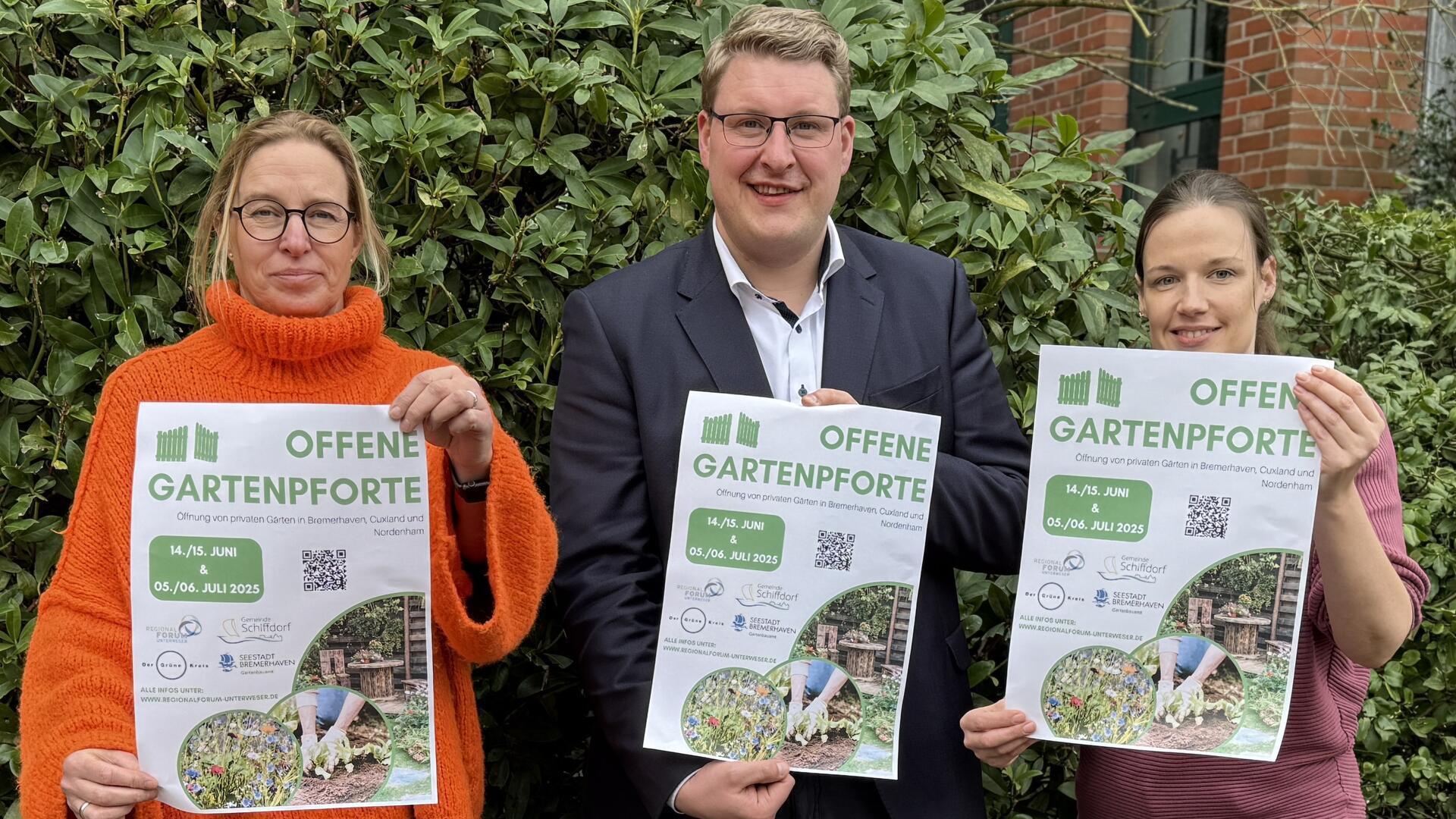 Zwei Frauen und ein Mann halten Werbeblätter für die "Offene Gartenpforte" in ihren Händen.