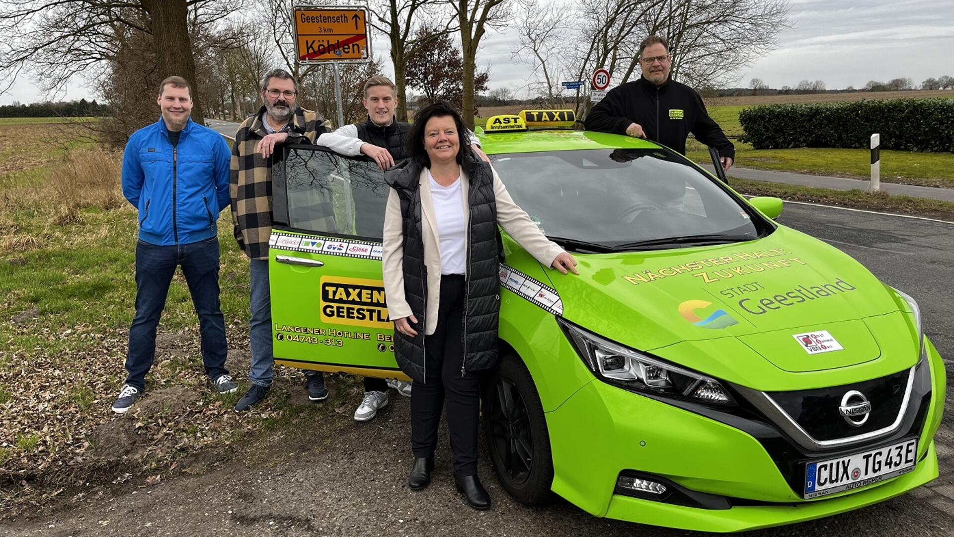 vier Menschen am grünen Taxi