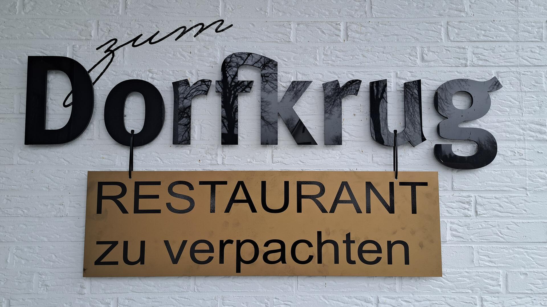„Restaurant zu verpachten“ steht auf einem Schild, das vor einem Haus steht. Für den Dorfkrug in Lunestedt wird ein neuer Pächter gesucht. 