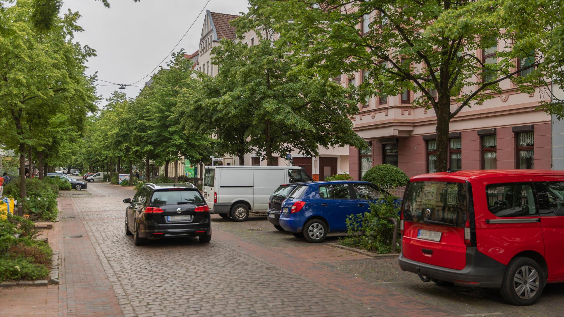 Auto fährt durch eine Wohnstraße. 