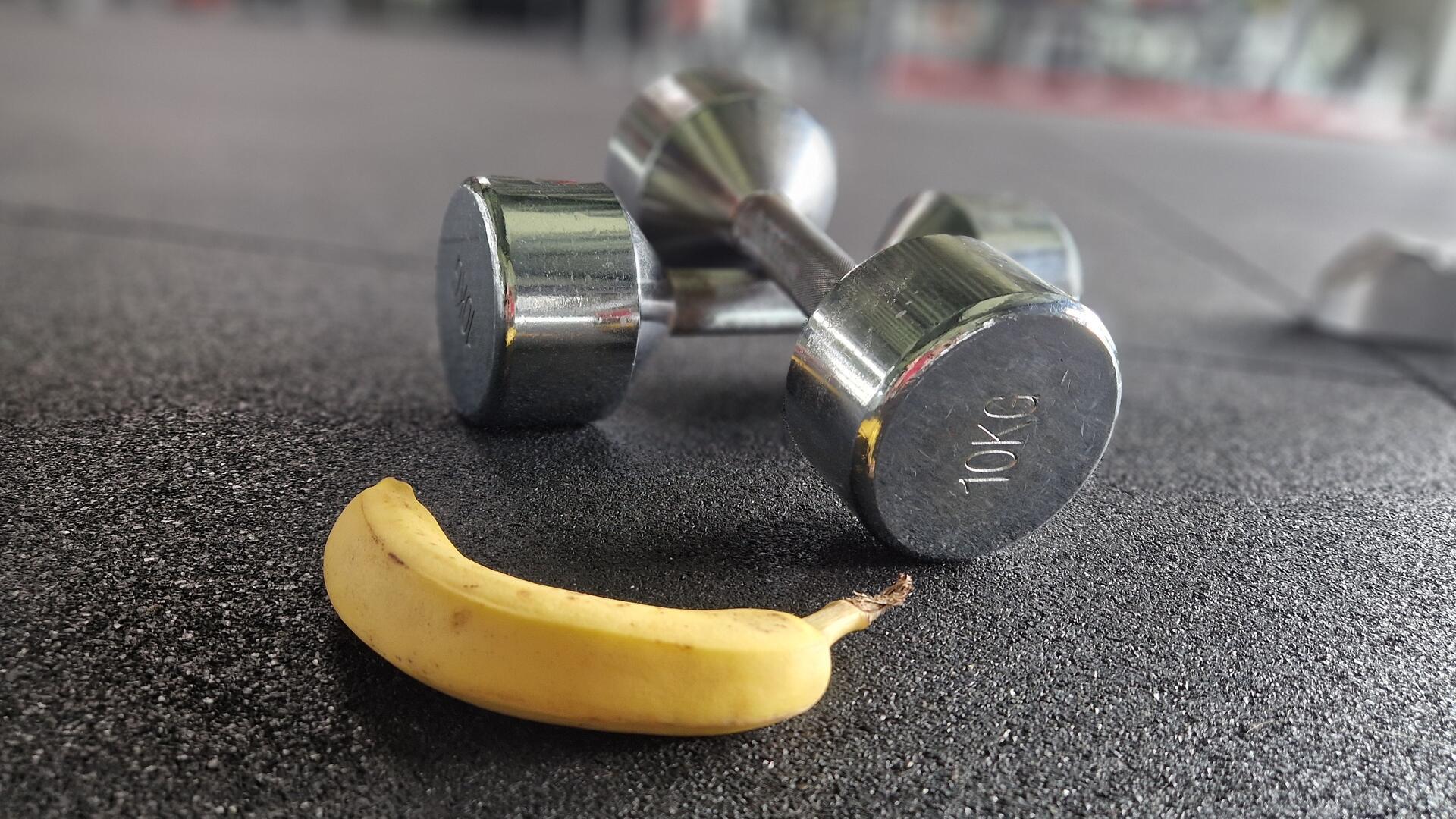 Eine Banane neben Hanteln.