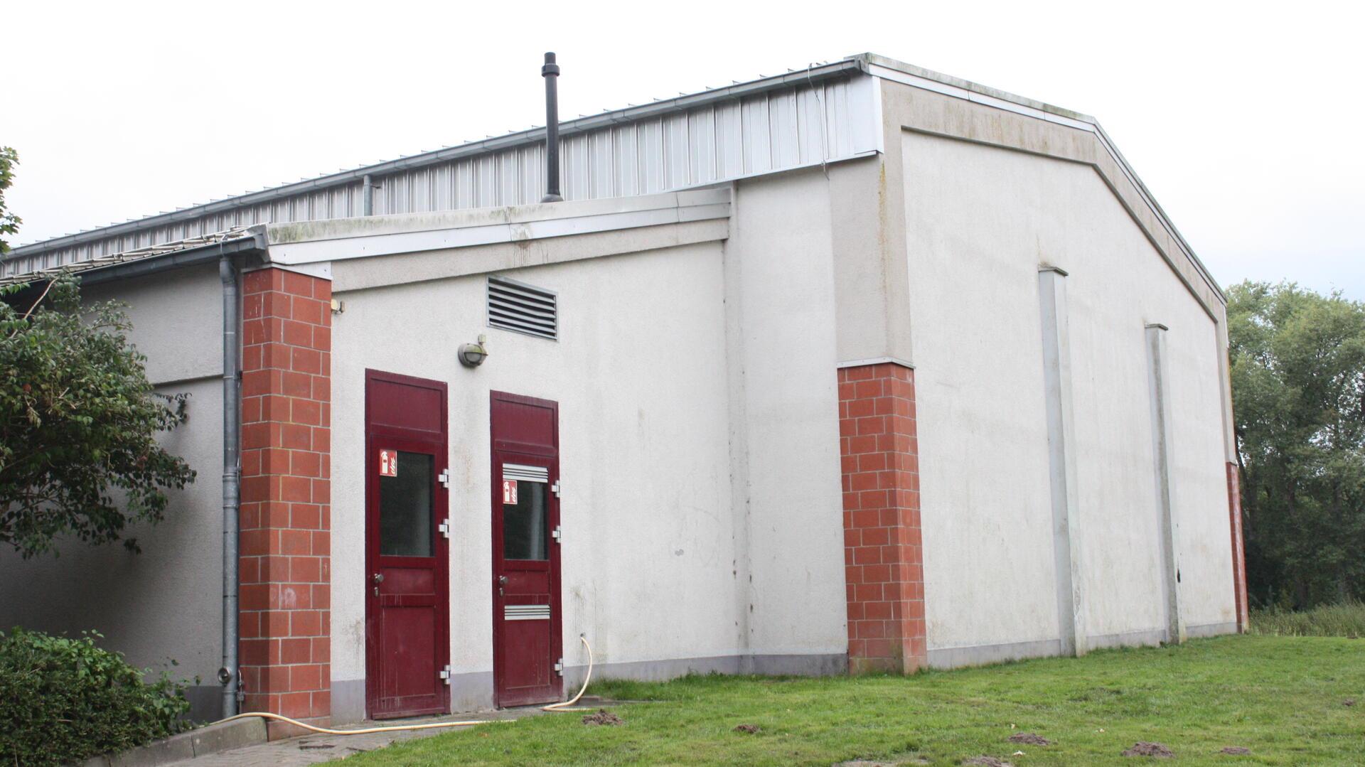 Weißes Haus mit dunkelroten Türen