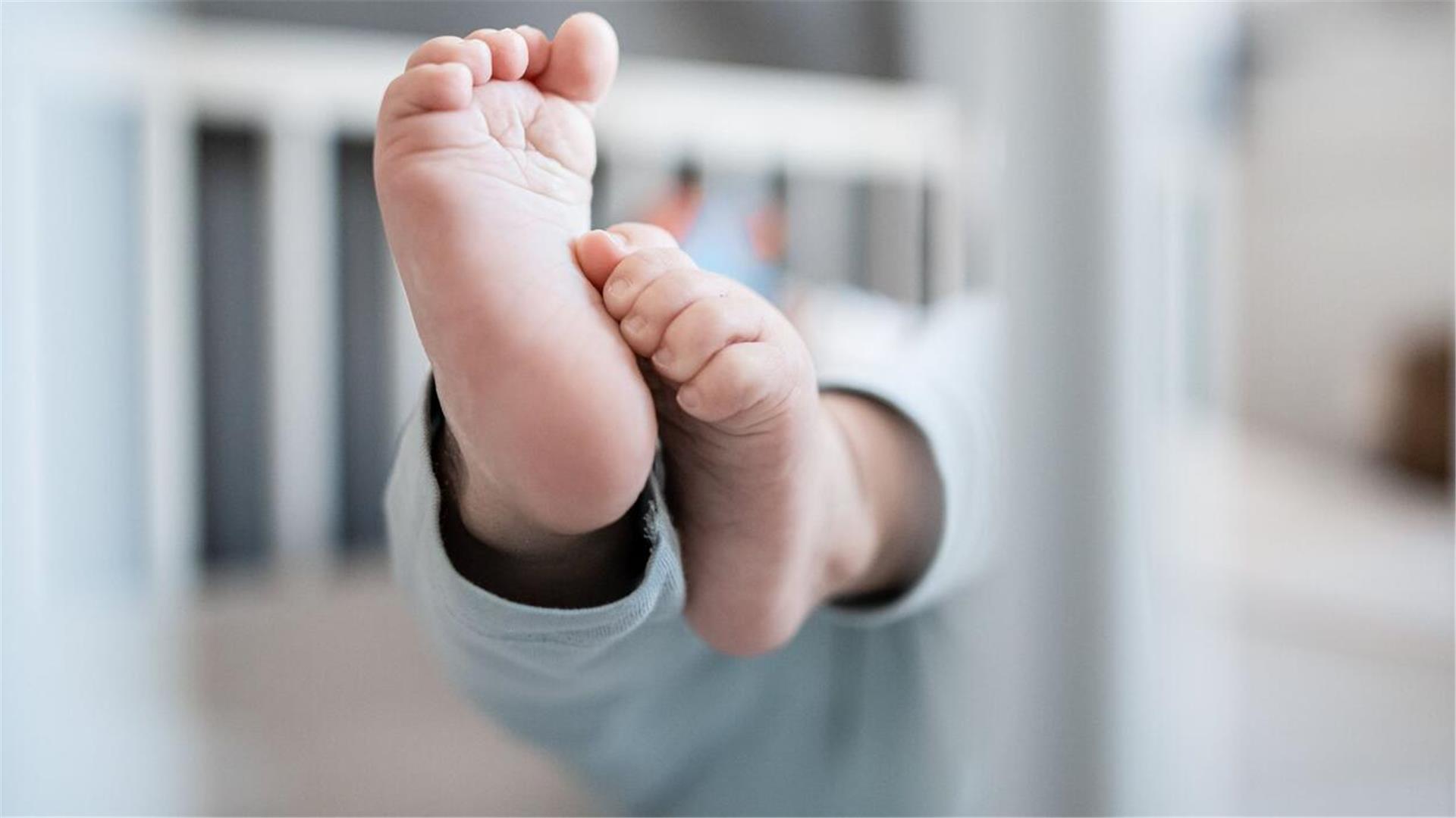 Die Füße eines Babys sind in einem Kinderbett zu sehen. Gesundheitswissenschaftler Lars Timm hat vorgeschlagen, alle Geburten in der Region in Bremerhaven zu konzentrieren. 