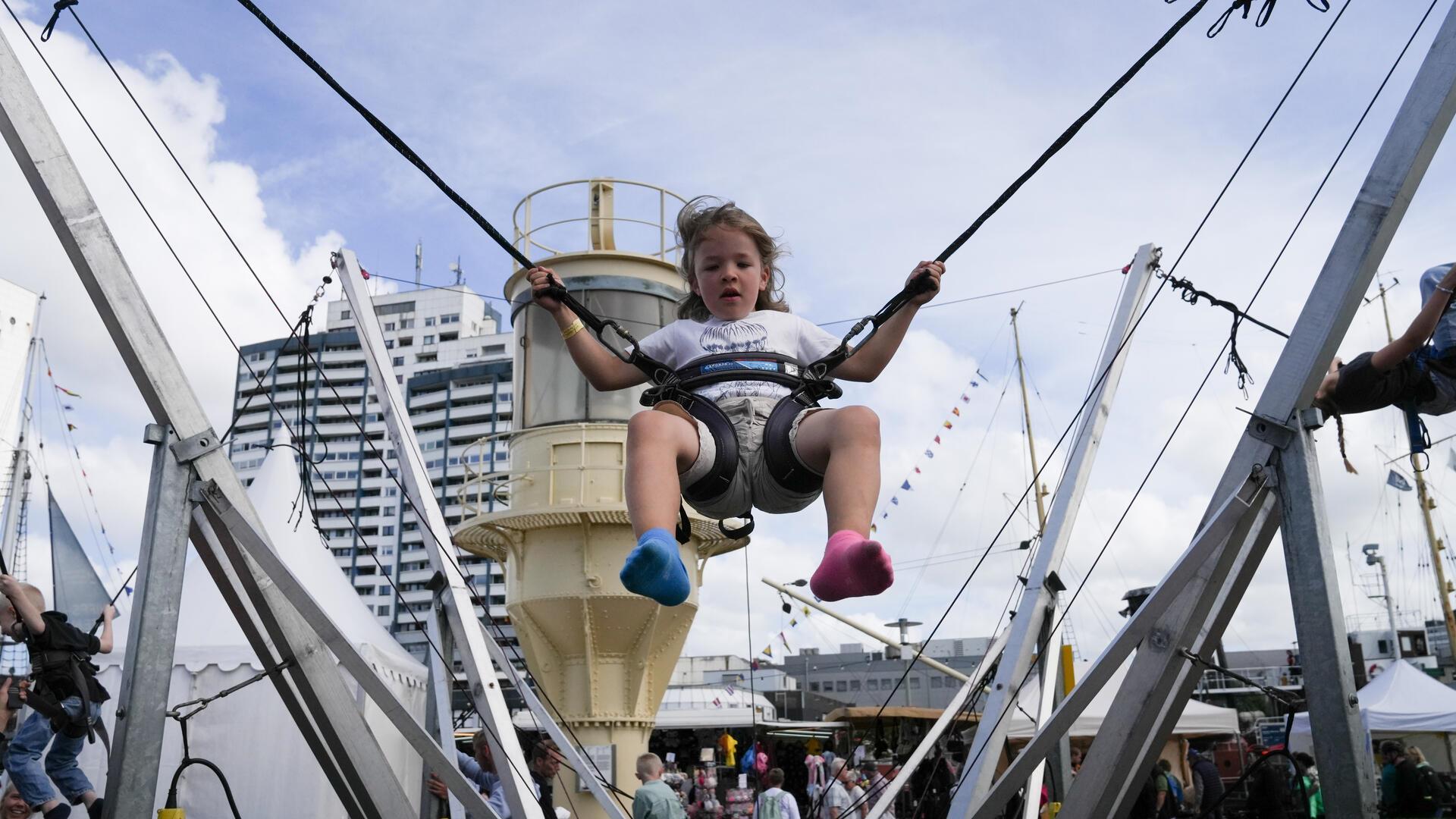 Ein Kind springt auf der Sail 2025 in Bremerhaven auf einem Trampolin.