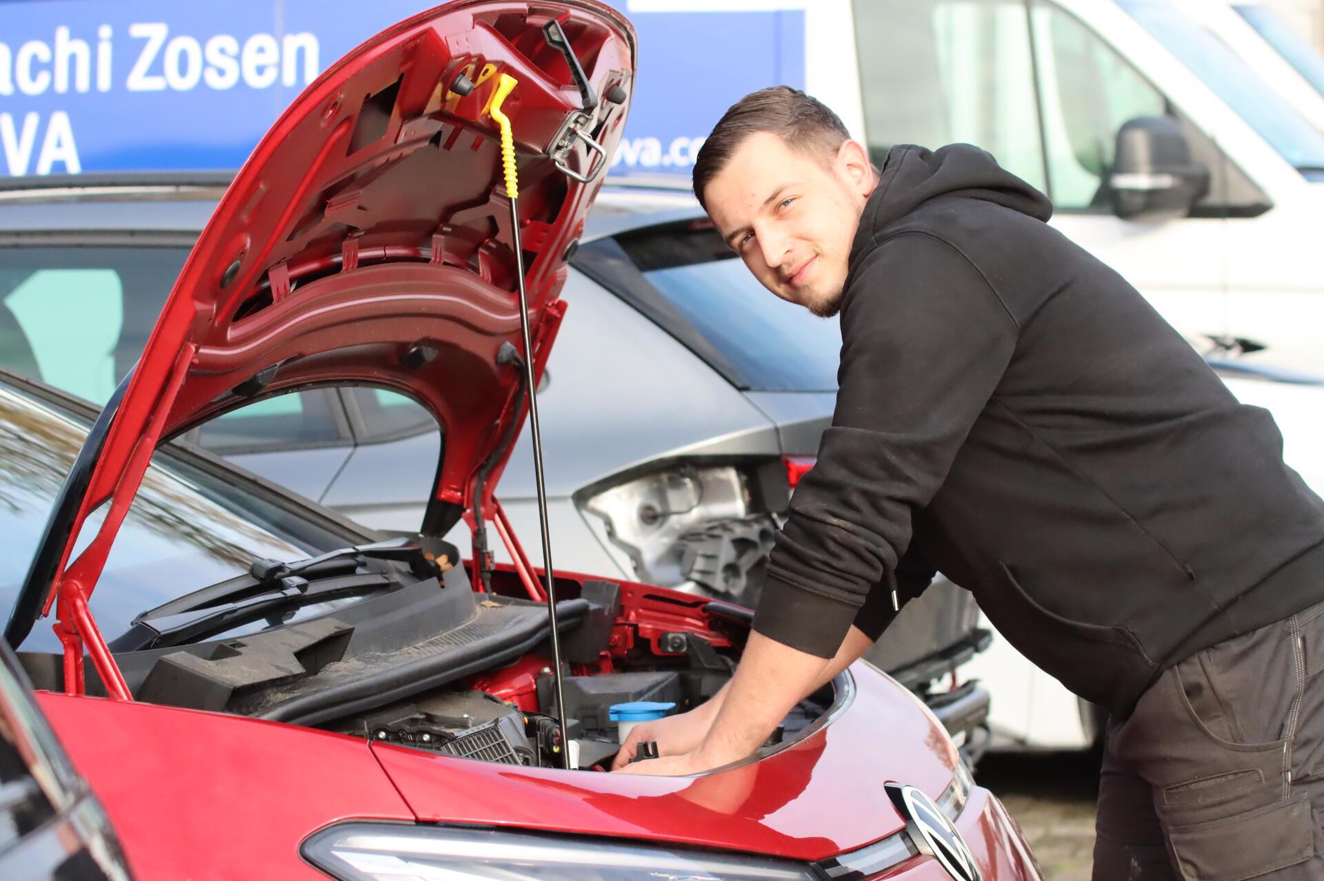 Ein Mann steht an einem Auto.