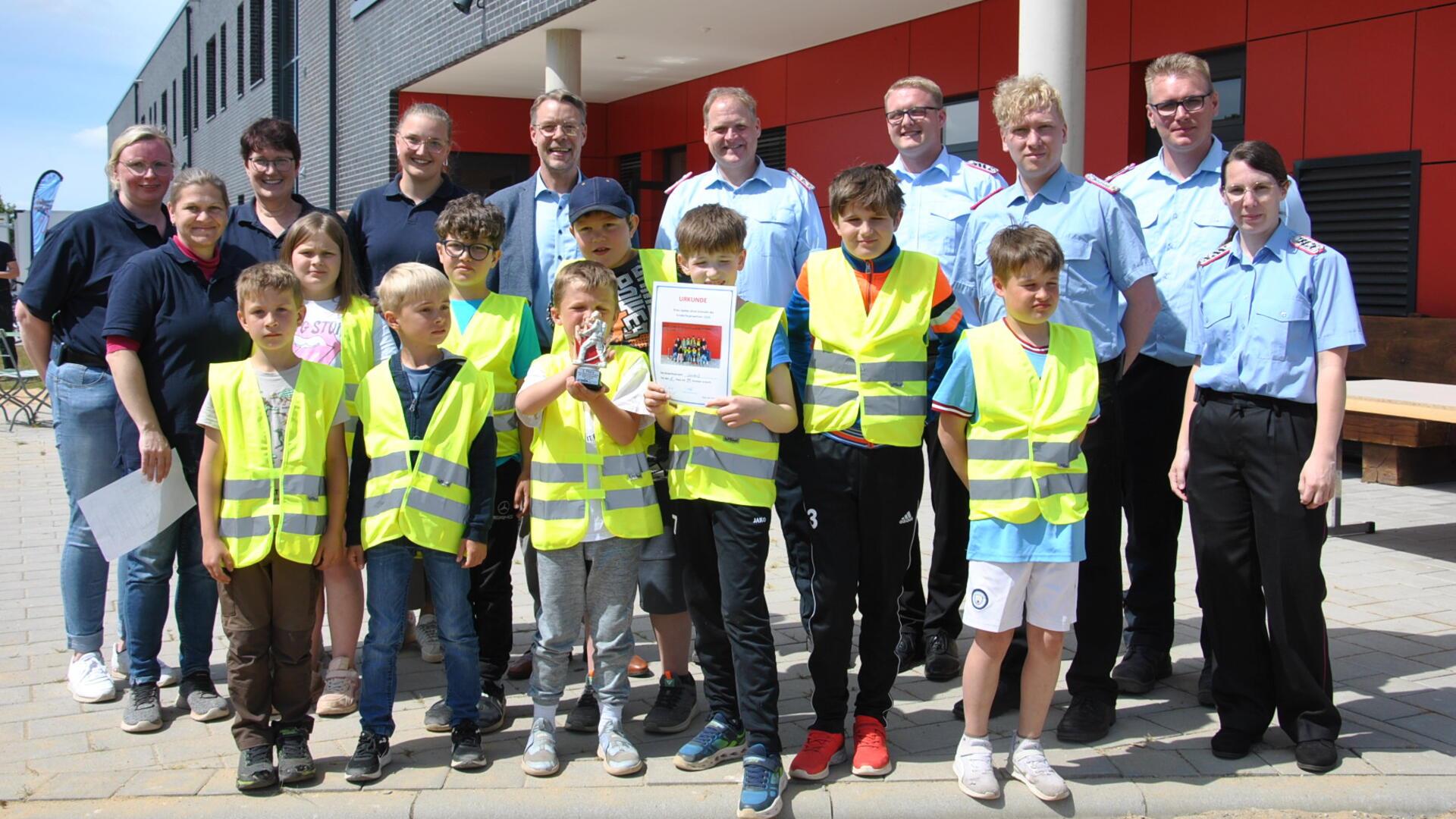 Holten den Sieg bei den „Spielen ohne Grenzen" in Zeven: die Kinderfeuerwehr aus Seedorf. Mit den Kindern freuen sich die Betreuer, Feuerwehrkameraden und Samtgemeindebürgermeister Henning Fricke.