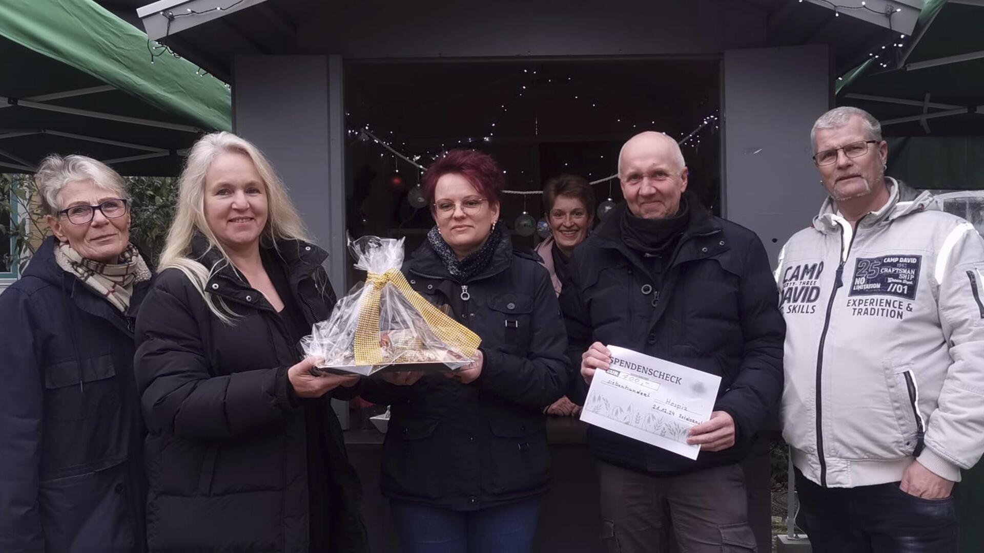 Hospiz-Mitarbeiterin Bianka Grieschow-Pülsch (Zweite von links) nimmt aus den Händen von Manuela Schulz eine Spende entgegen. Drei befreundete Kuhstedter Ehepaare hatten einen kleinen „Weihnachtsmarkt“ veranstaltet.