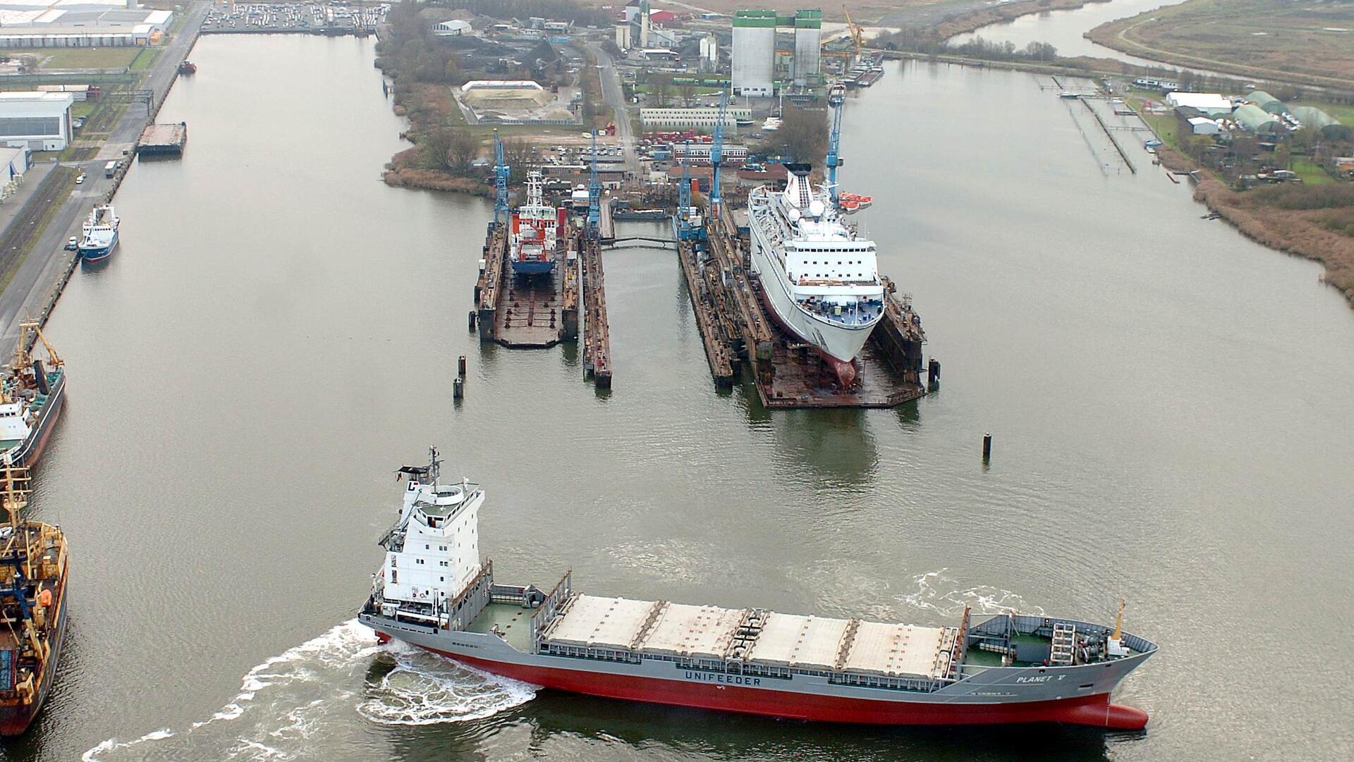 Schiff vor den Schwimmdocks einer Werft.