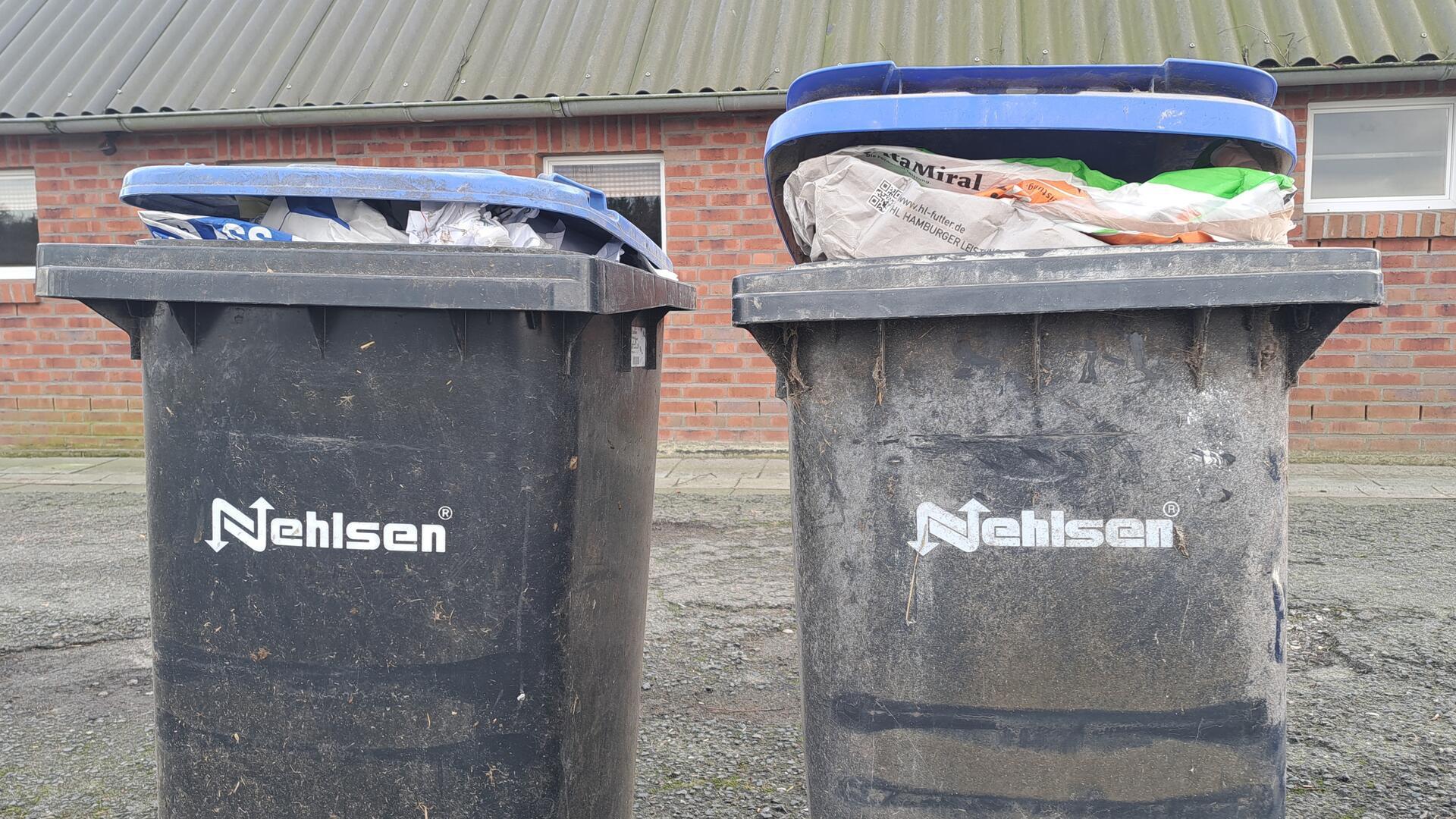 Vollgestopfte Mülltonnen stehen vor einem Gebäude. Viele Mülltonnen im Landkreis Cuxhaven sind während des Streiks der Nehlsen-Mitarbeiter nicht geleert worden. 