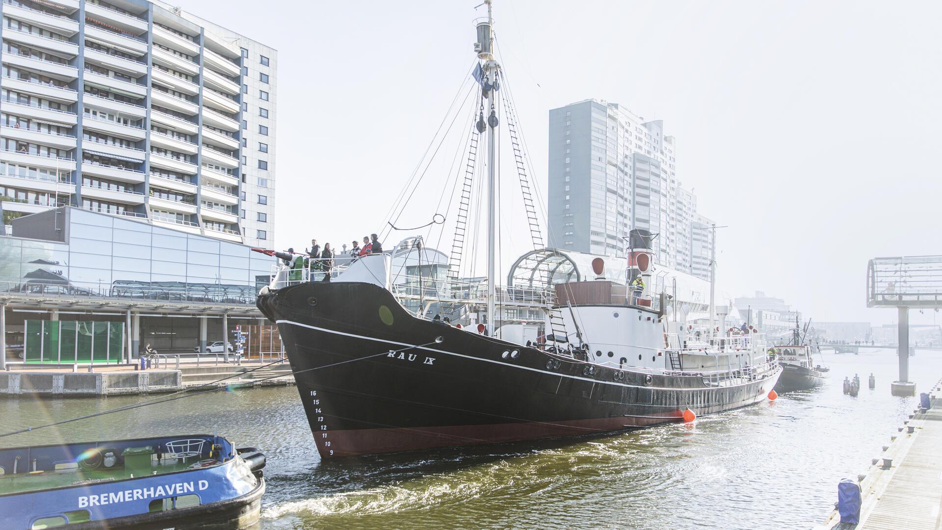 Schiff vor Häuserkulisse. 
