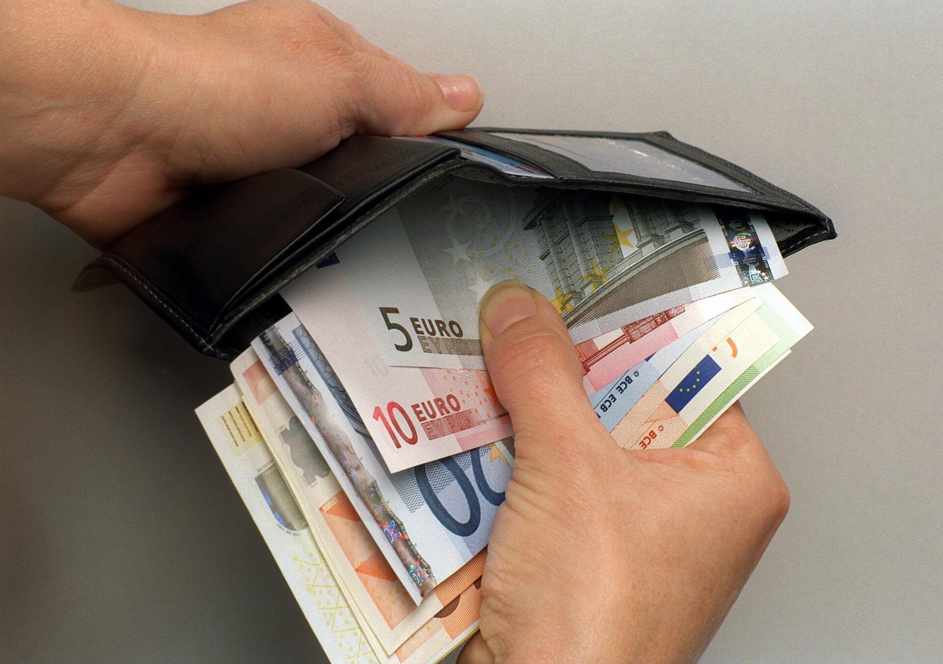 Ein Mann verstaut einige  Euro-Geldscheine in seiner Geldbörse. Immer mehr Senioren in Bremerhaven werden Opfer von Taschendieben, die beim Einkaufen zuschlagen.