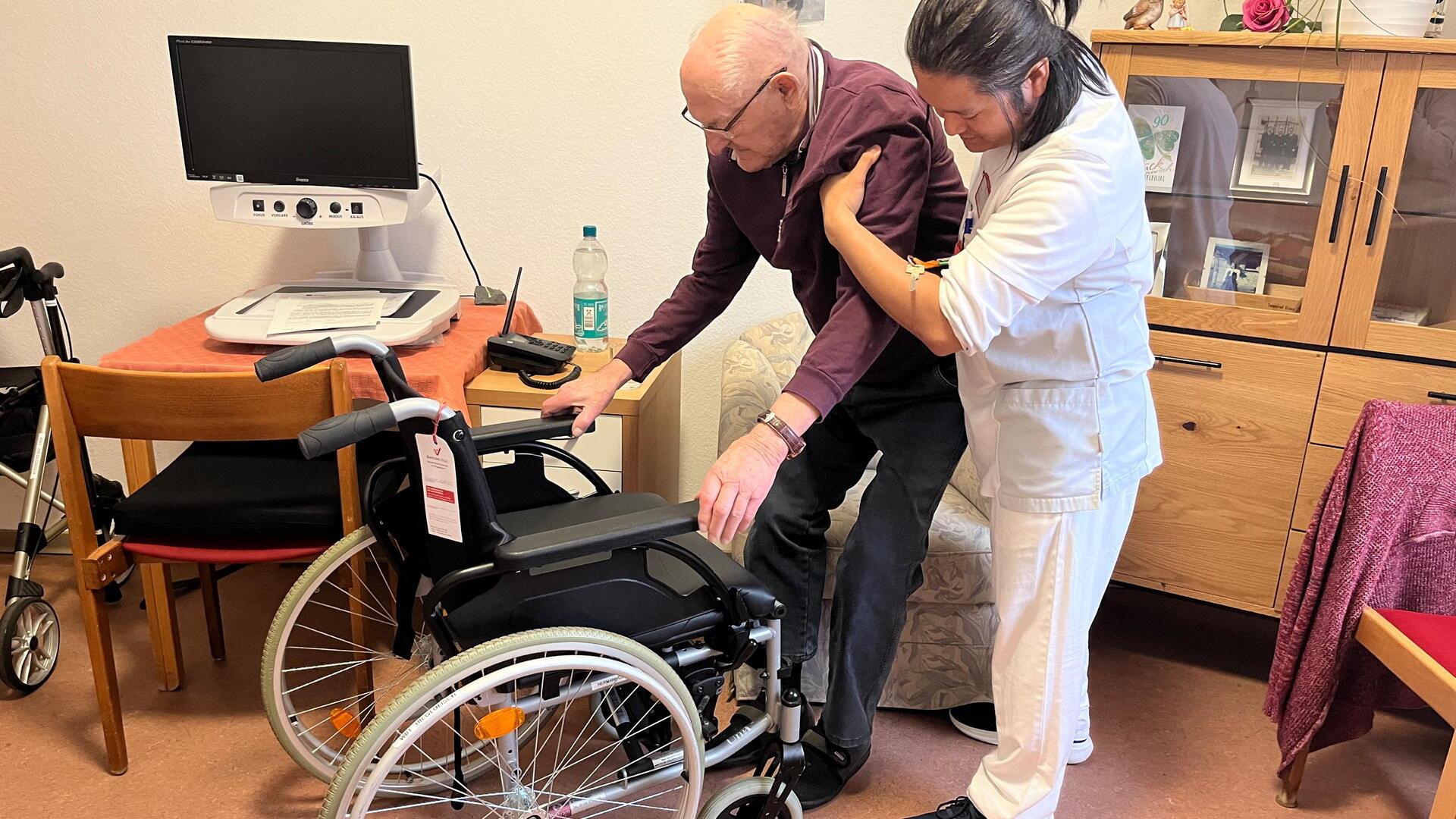 Eine Pflegekraft unterstützt einen Bewohner in einem Pflegeheim.