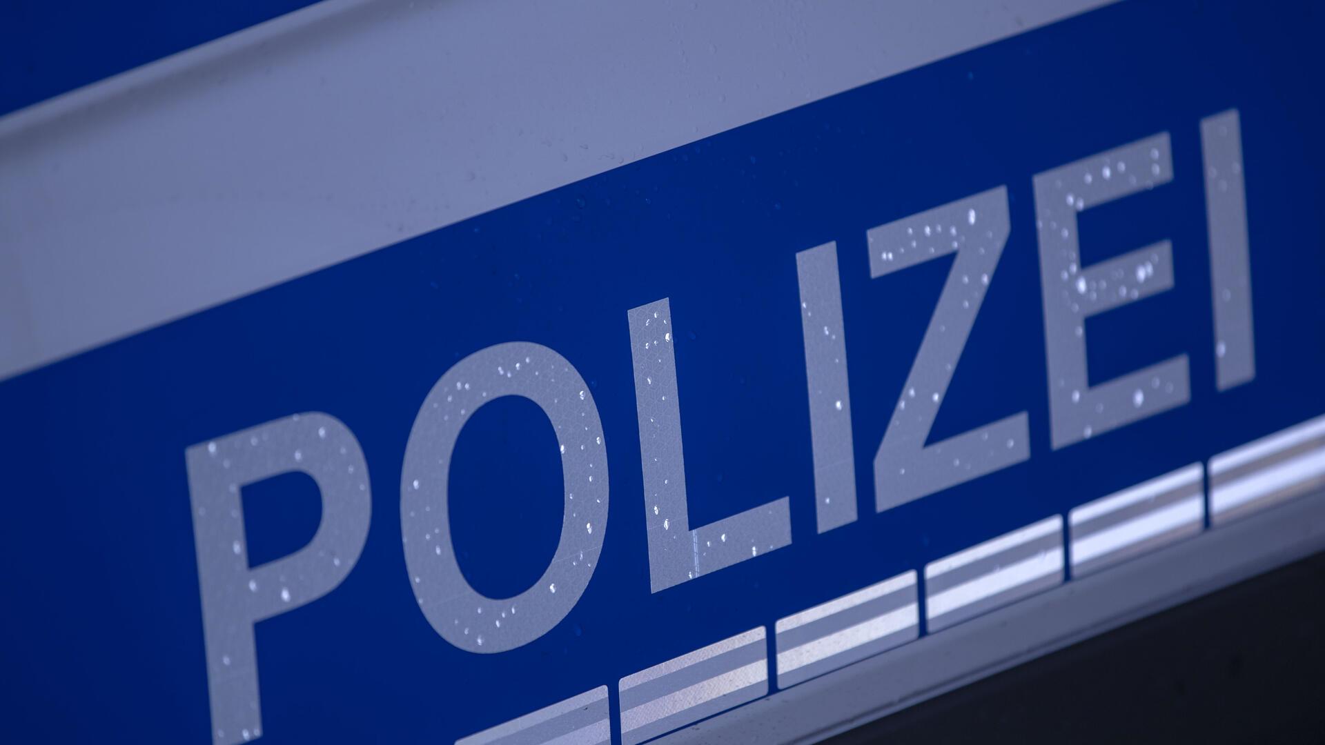 weiße Aufschrift Polizei auf blauem Grund