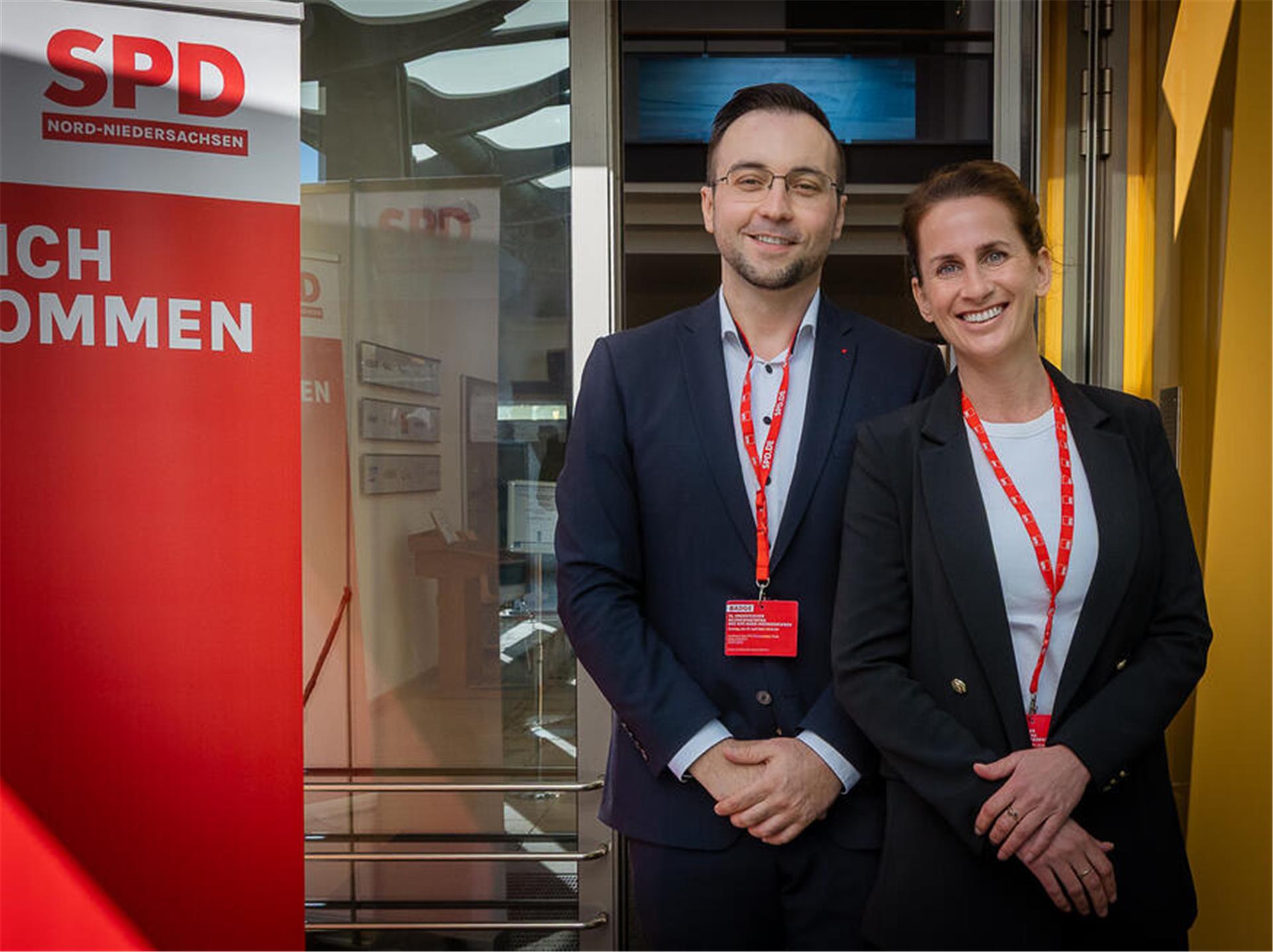 Ein Mann (links) und eine Frau in einem Gebäude, links ist ein roter Banner zu sehen und die weißen Buchstaben SPD. Ina Helwig und Sebastian Brandt: Die SPD im Kreis Rotenburg setzt nach eigenen Angaben auf Bürgernähe und Sachpolitik.