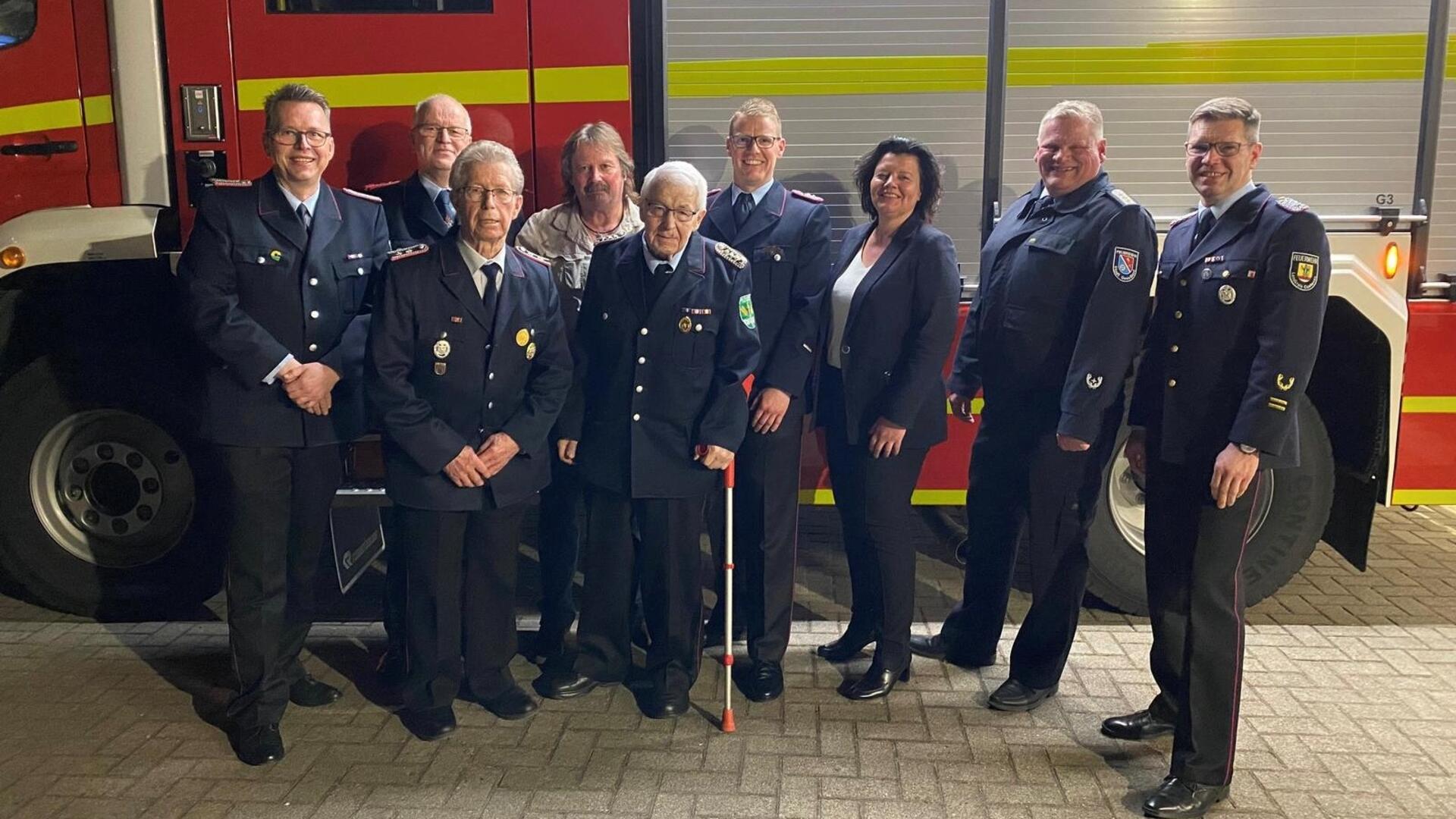 Mitglieder der Ortsfeuerwehr Sievern stehen vor einem Löschfahrzeug. 