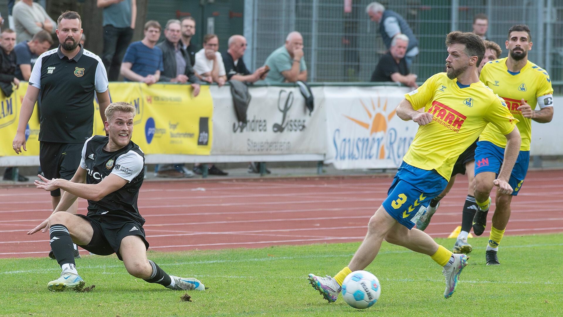 Jarno Böntgen ist schneller am Ball und kann auf seinen Mitspieler passen. Im Hintergrund verfolgt Trainer Malte Bösch die Szene.