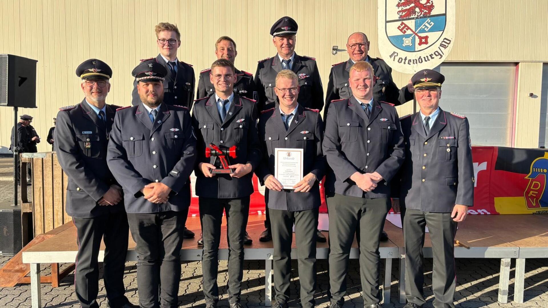Joris Hastedt (hintere Reihe, von links), Kevin Ahrens, Marko Hastedt, Klaus BredehöftRotenburgs Kreisbrandmeister Peter Dettmer (vorne, von links)), Lüder Böse, Lennart Bredehöft, Jendrik Stemmermann, Torge Stemmermann und Jörg Suske (Abschnittsleiter Bremervörde) freuen sich über den vierten Platz bei den Regionalwettkämpfen der Feuerwehren. 2026 werden sie beim Landesentscheid antreten. 