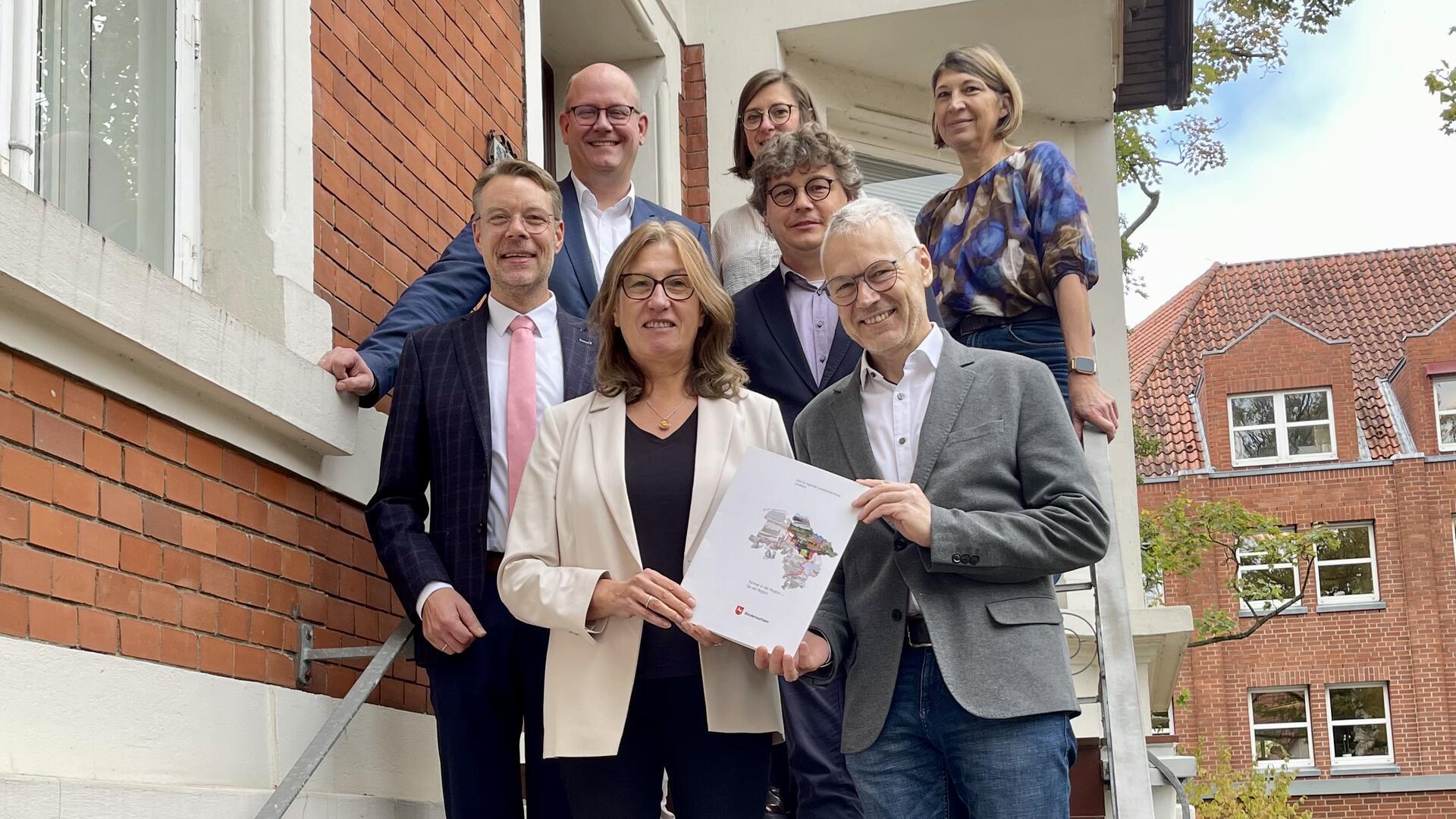 Karin Beckmann überreicht die Mittelteilung zum Programmjahr 2025 der Stadt Zeven an Bürgermeister Jens Petersen und Stadtdirektor Henning Fricke.