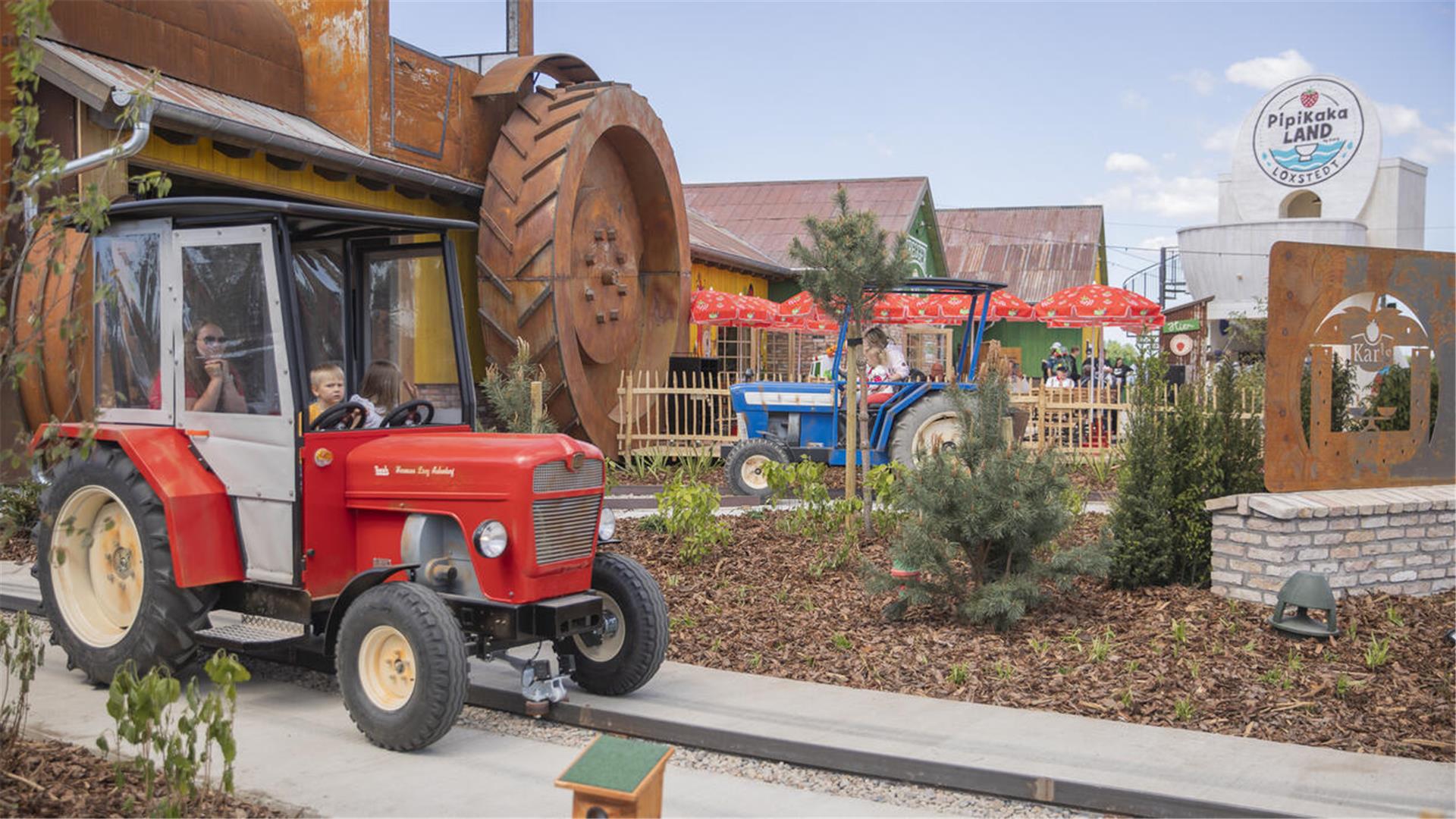 Ein roter Traktor als Teil eines Freizeitparks. 