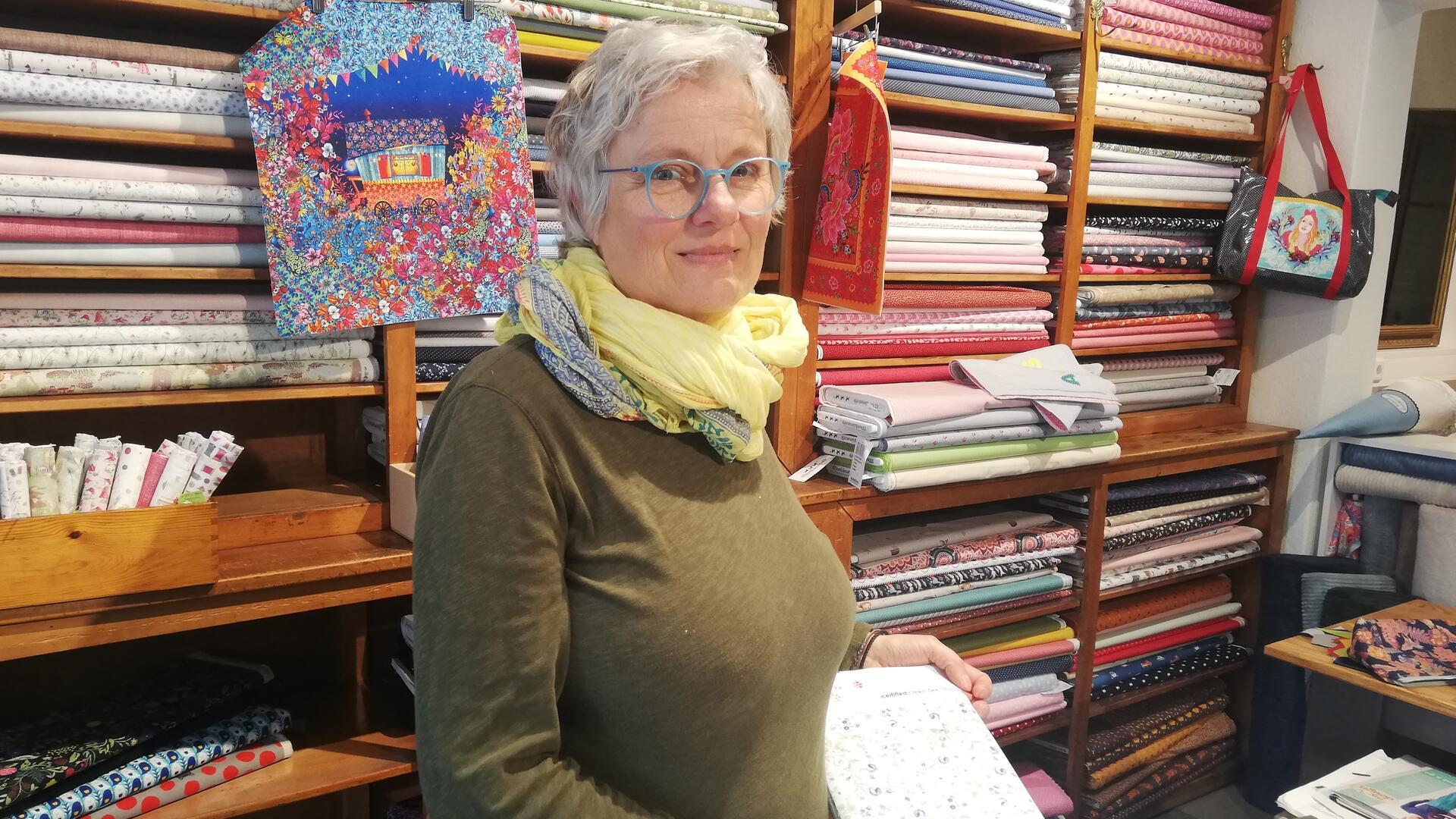 Eine Frau mit Brille vor einem Regal mit Stoffballen. Katrike Schloßhauer muss ihren Laden in der Hafenstraße schließen.