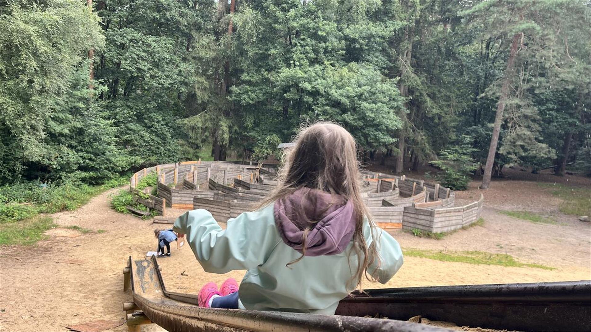 Ein Kind rutscht von der großen Rutsche. Spielplatz Zevener Holz.