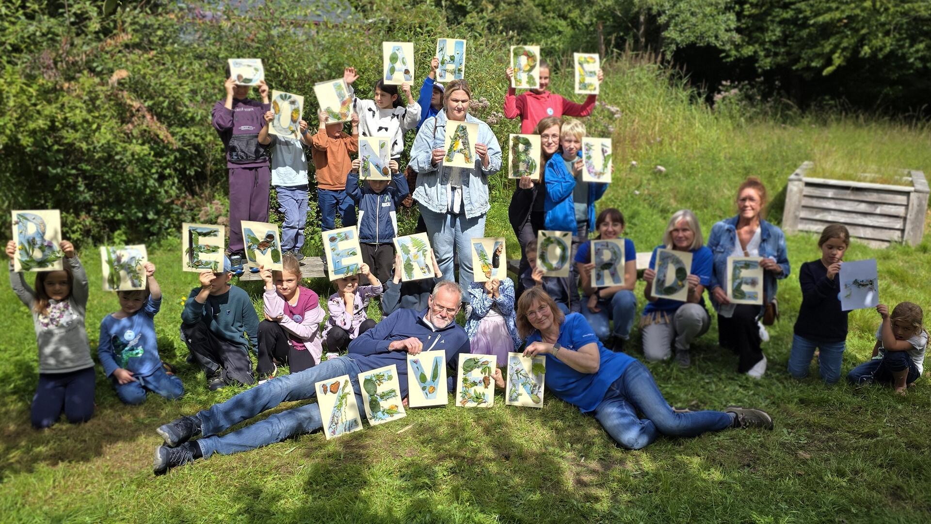 Kinder hatten am Vormittag aus Naturmaterialien des Umweltpyramide-Gartens die 28 Buchstaben „50 Jahre NABU Bremervörde-Zeven“ auf 28 DIN A4-Blätter geklebt. 