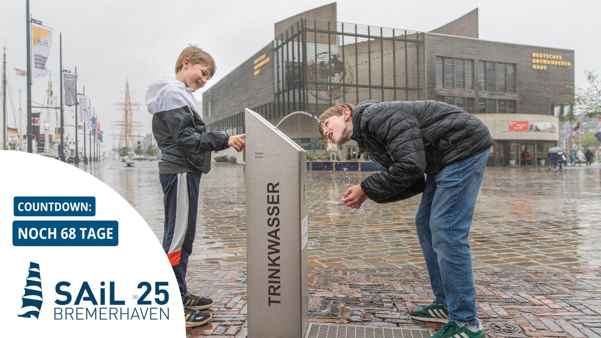 Zwei Jungs bedienen sich am Trinkwasser-Spender am Neuen Hafen.