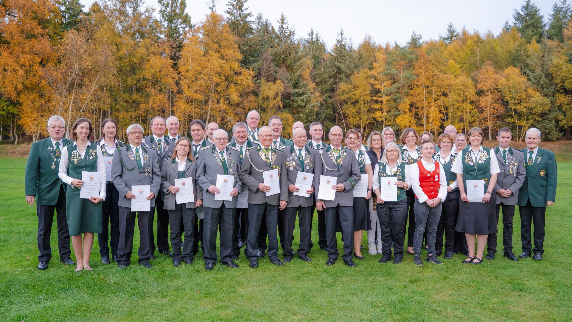 Kreispräsident Holger Rubach (links) und sein Stellvertreter Werner Martens (rechts) mit den geehrten Schützinnen und Schützen des Schützenkreises Bremervörde.