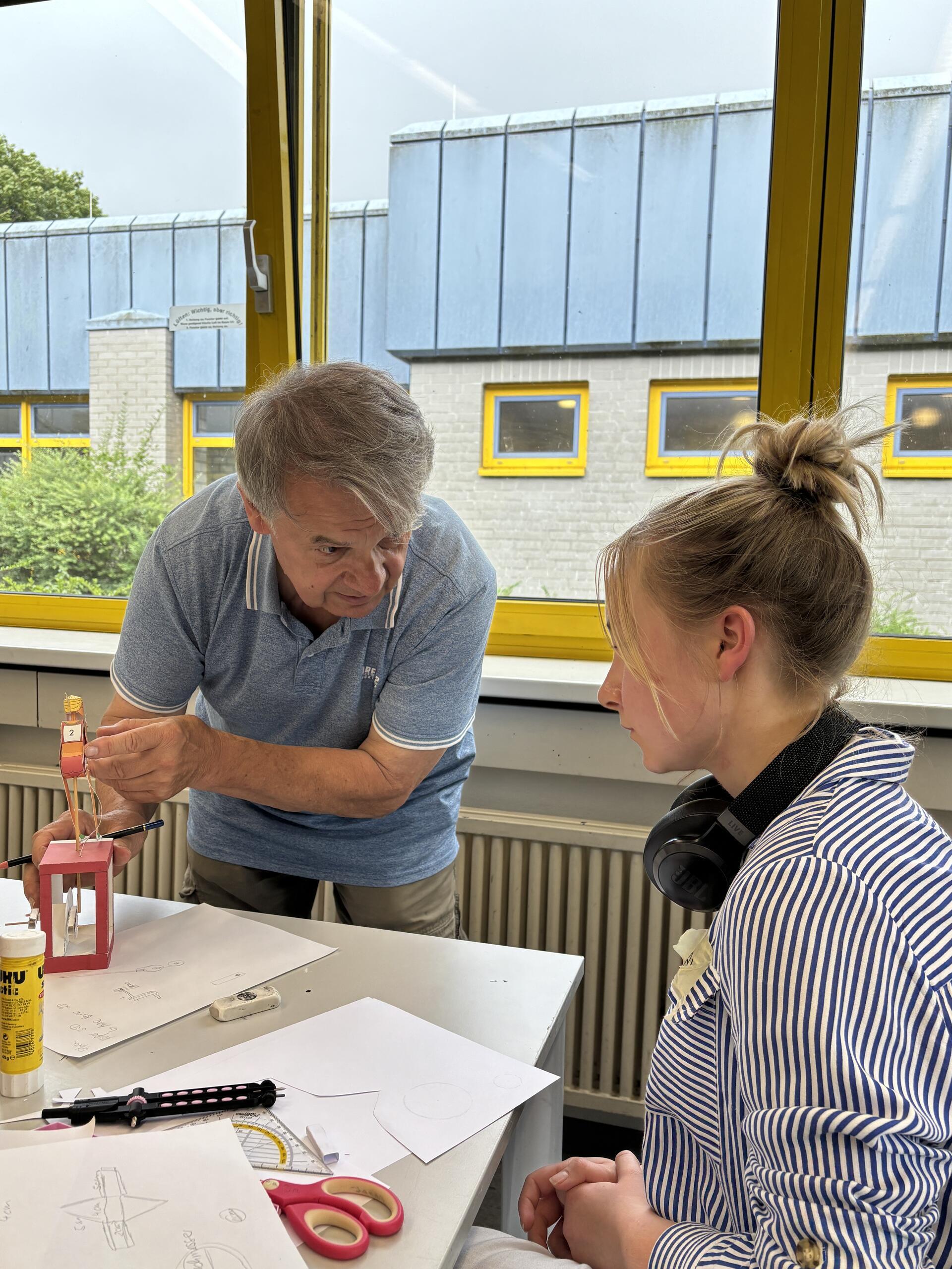 Künstler Walter Ruffler bespricht mit Zehntklässlerin Alex die Mechanik ihrer geplanten Papierskulptur.