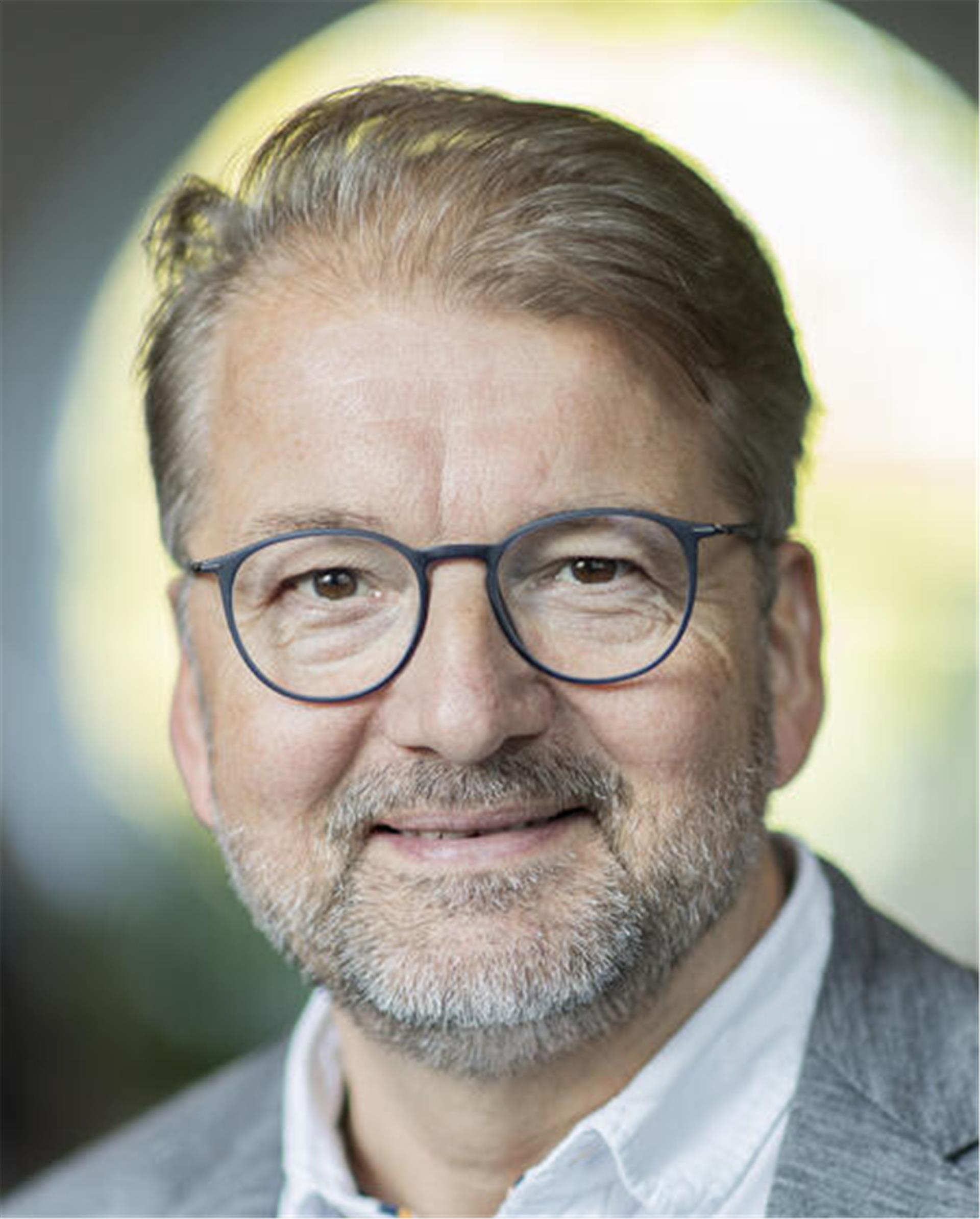 Ein Mann mit Brille und Dreitagebart.