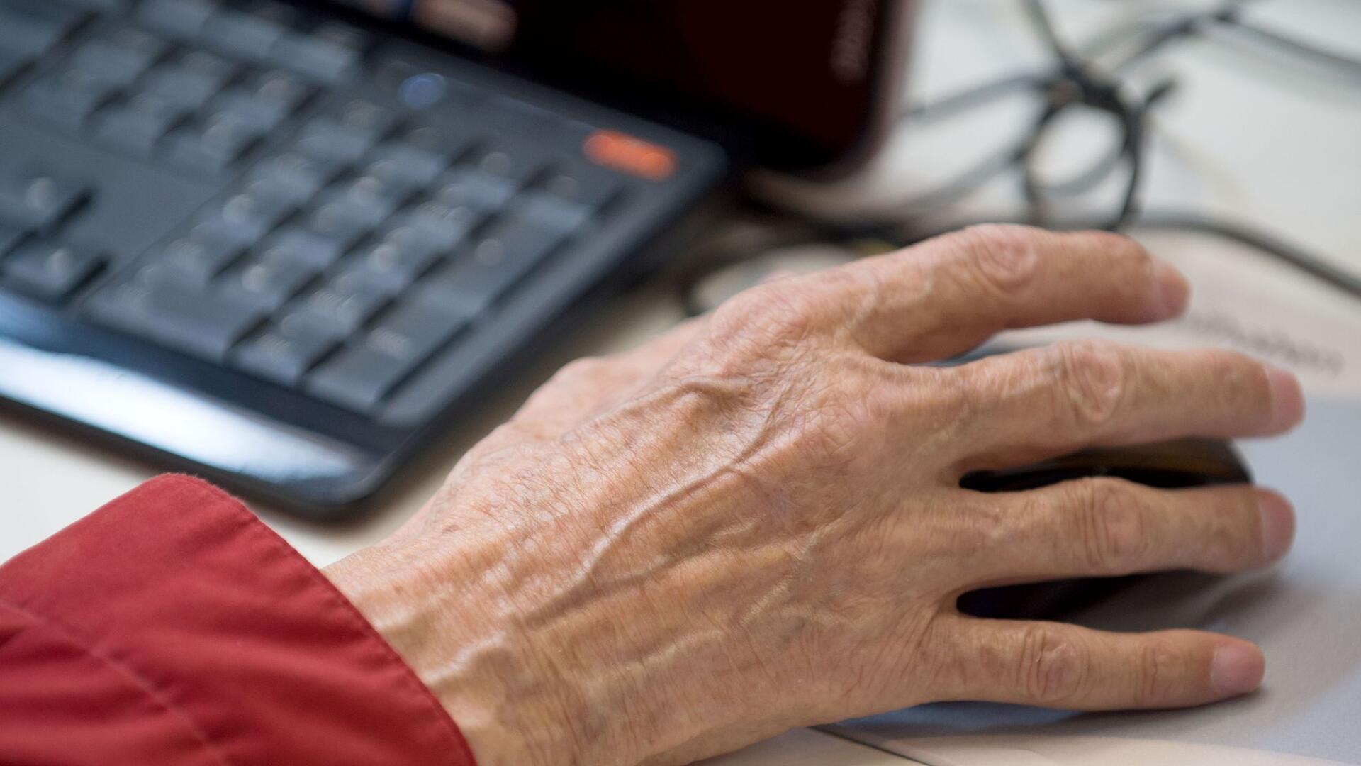 Ein älterer Mann sitzt an einem Computer.