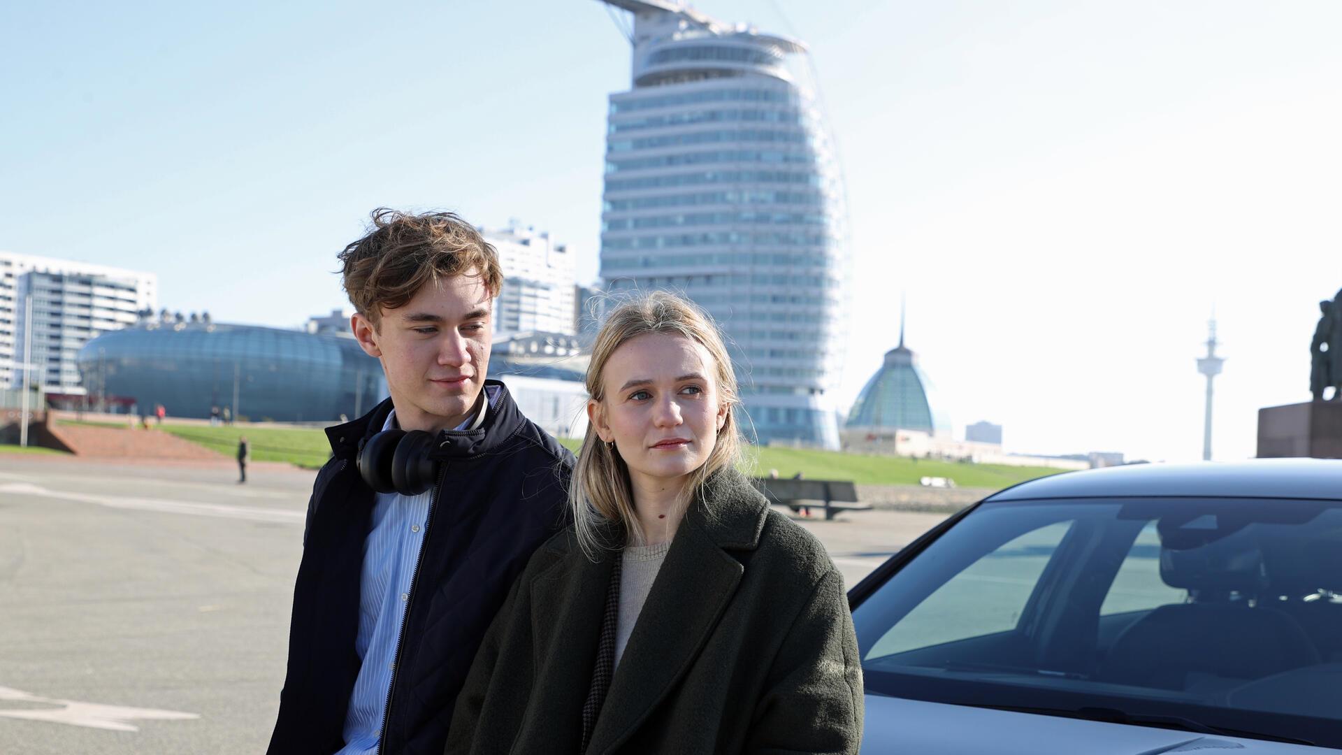 Ein junger Mann und eine junge Frau stehen in Bremerhaven vor dem Hotel Sail City.