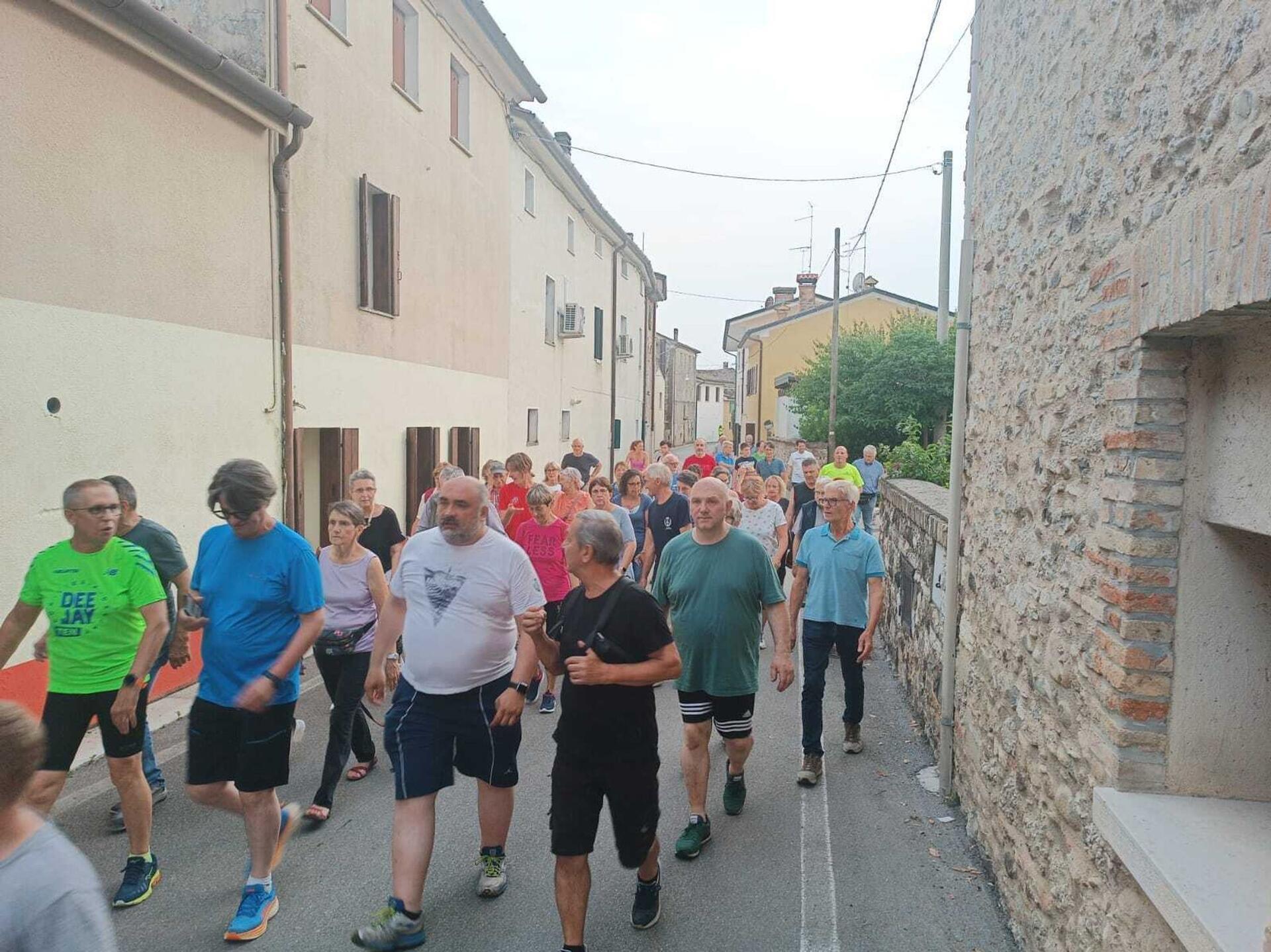 Skurrile Highlights 2024: Eigentore, Chaoskatze und Kurioses Luciano Fregonese (M, im grauen T-Shirt), Bürgermeister von Valdobbiadene, läuft mit einer Gruppe seiner Bürger durch die Straßen seiner Gemeinde.