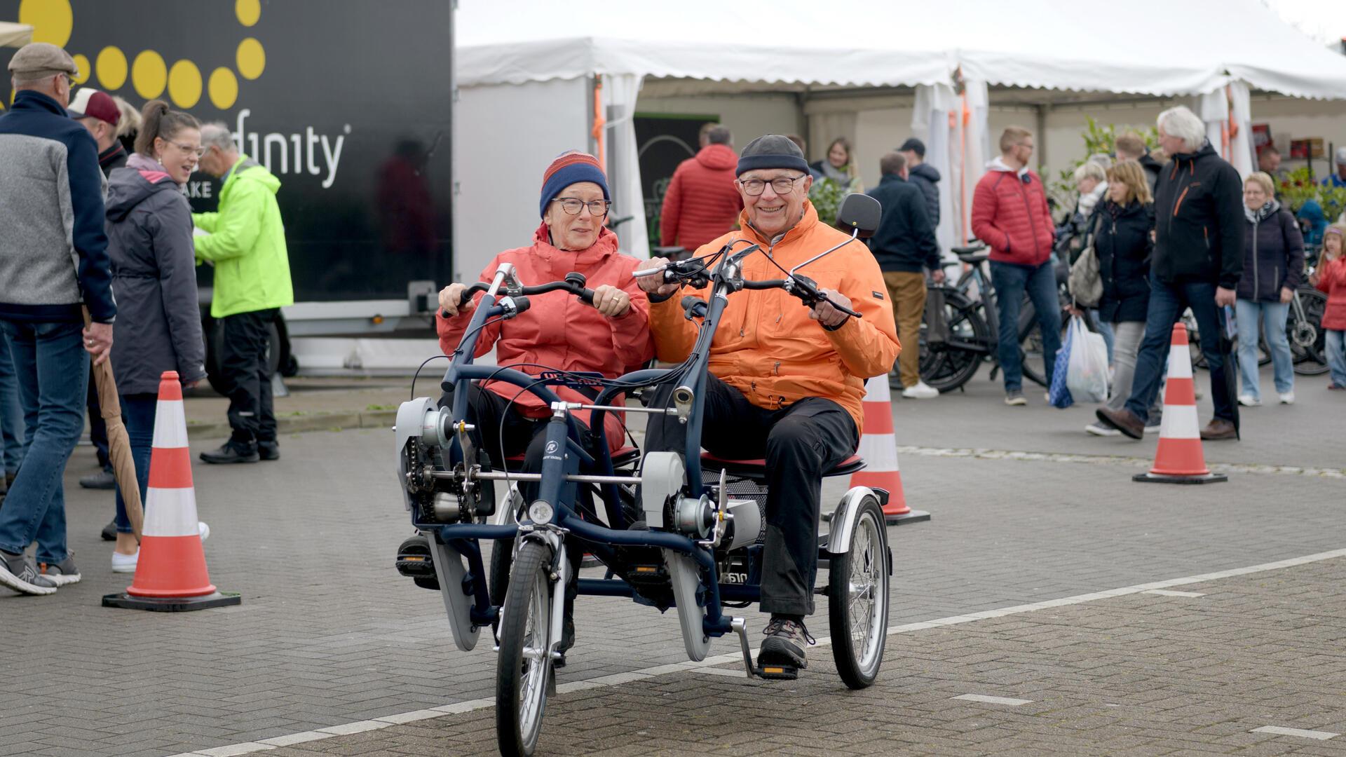 Ein Mann und eine Frau sitzen auf einem Spezialfahrrad. Magrit und Wilhelm Buck probierten ein „Sociable“, ein Parallel-Tandem der Erlebnis Bremerhaven aus.