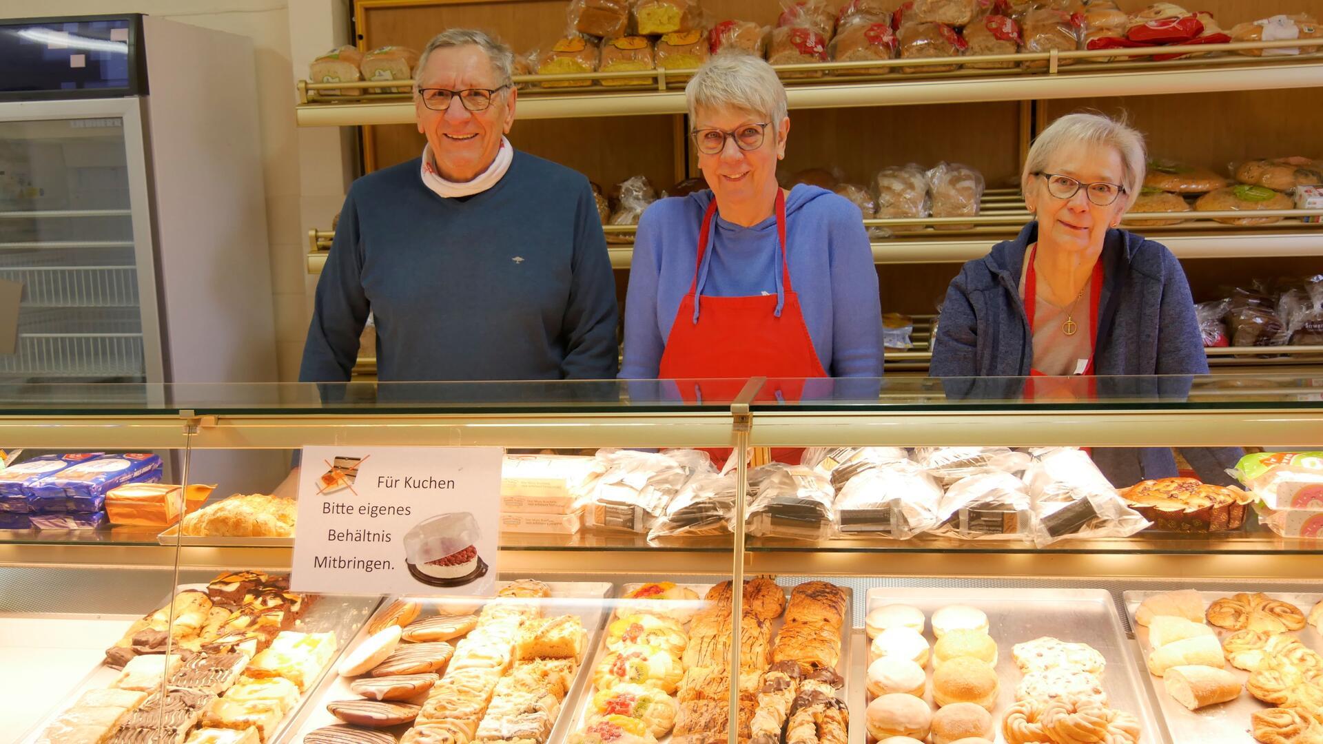 Ein Mann und zwei Frauen stehen hinter einem Verkaufstresen von Backwaren. Die drei arbeiten ehrenamtlich für die Tafel in Tarmstedt.