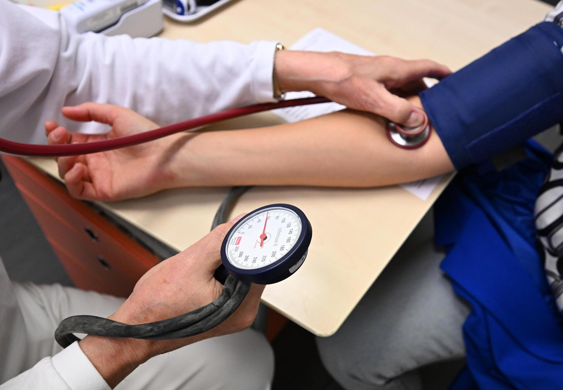 Ein Arzt misst bei einem Patienten den Blutdruck