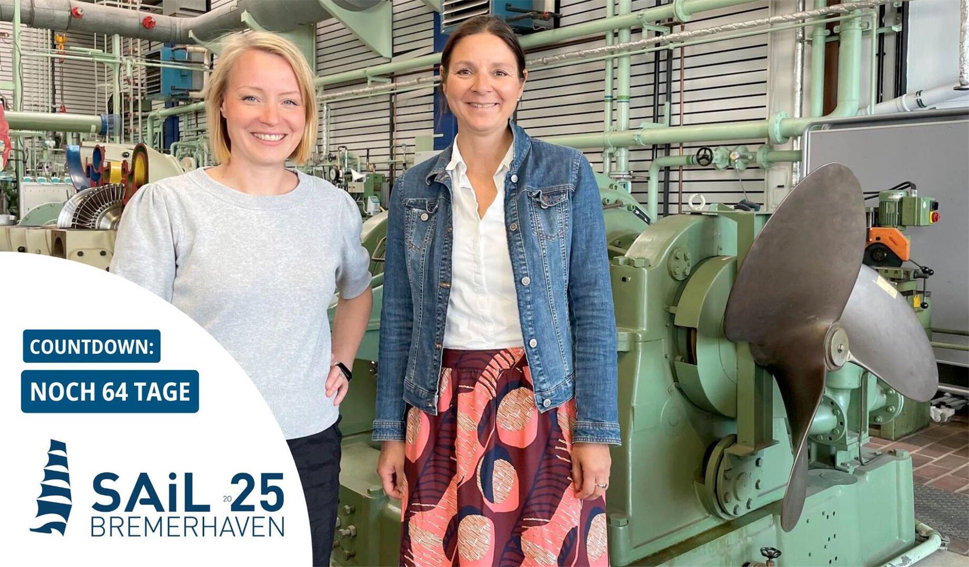 Zwei Frauen in einem Maschinenraum. Sie stehen vor einer Schiffsschraube.