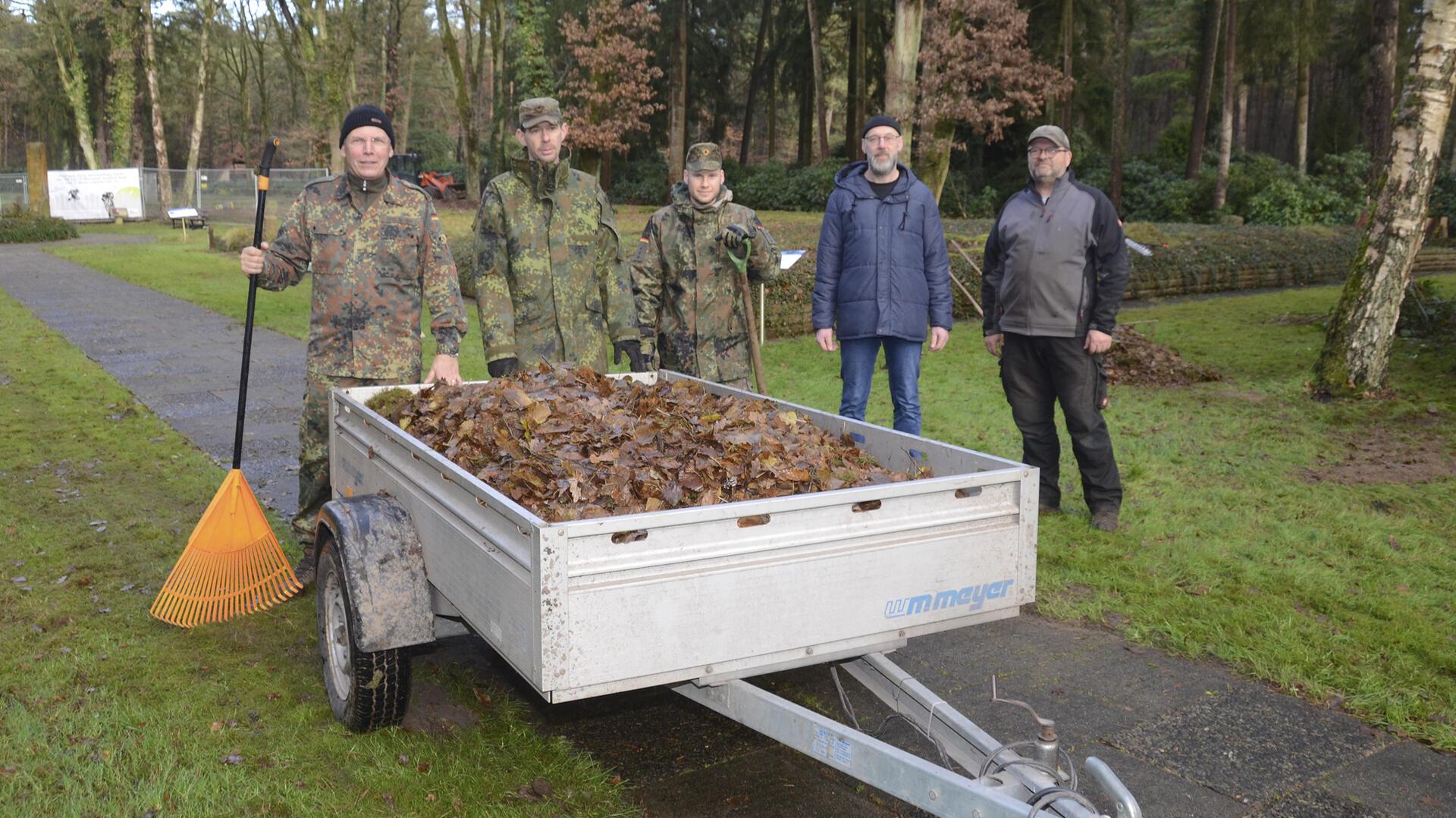 Militärpfarrer Andreas Spelmeyer (links) hatte die Idee, Sandbostels Gemeindebürgermeister Michael Behnken (Zweiter von rechts) und Gemeindegärtner Matthias Heitmann fanden sie super. Also packten 35 Soldaten der Logistikschule der Bundeswehr in Garlstedt einen Tag lang auf der Kriegsgräberstätte in Sandbostel mit an.