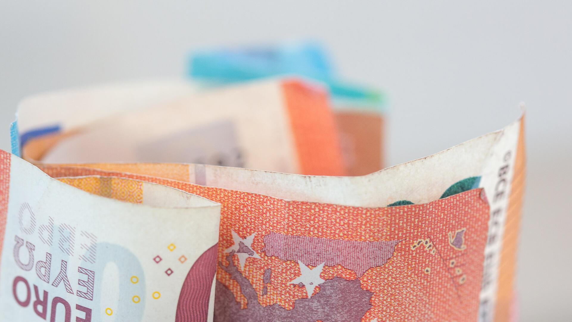 Euro-Banknoten sind in einem Glasgefäß aufbewahrt. 