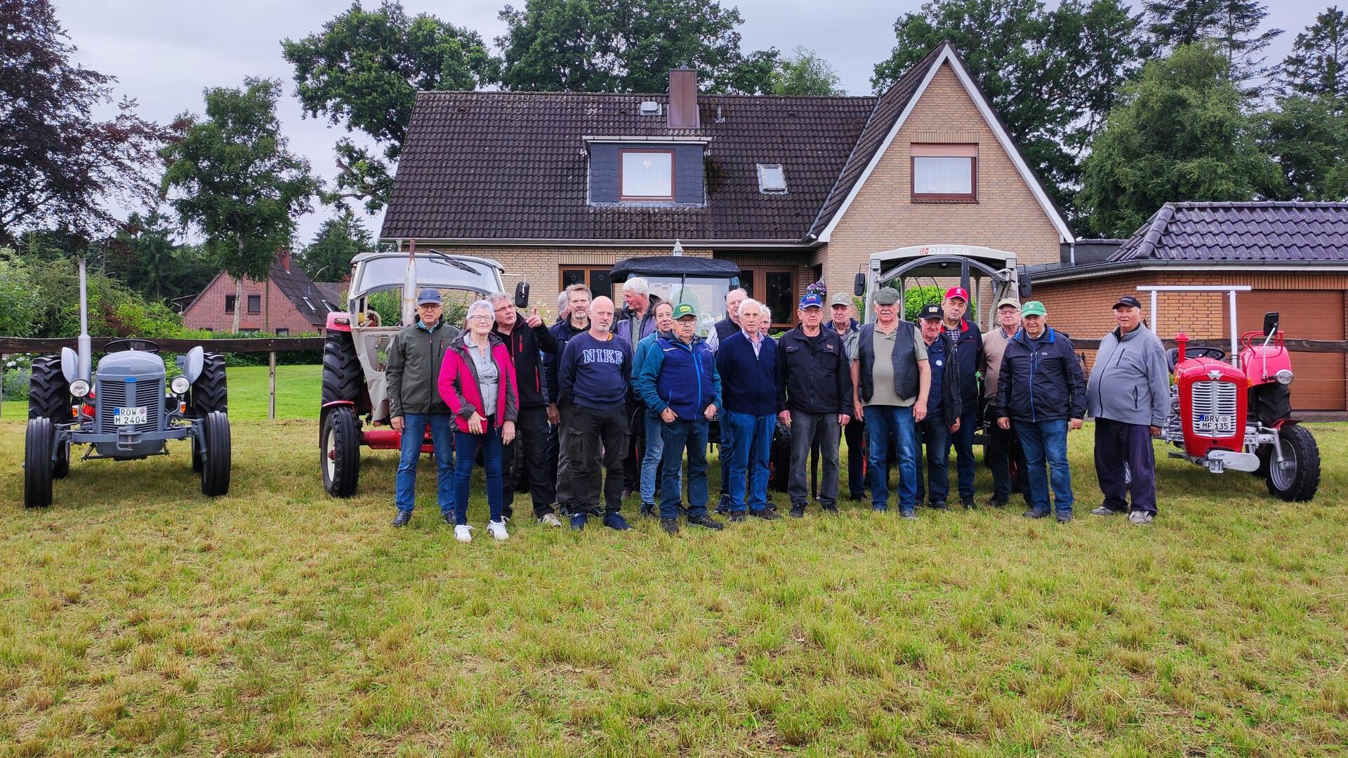 Menschen und Traktoren haben sich zu einem Gruppenfoto aufgestellt. Mit 18 Traktoren unterwegs: Die Teilnehmer der Moordörfer-Tour besuchten geschichtsträchtige Orte und erinnerten an das Wirken von Jürgen Christian Findorff.