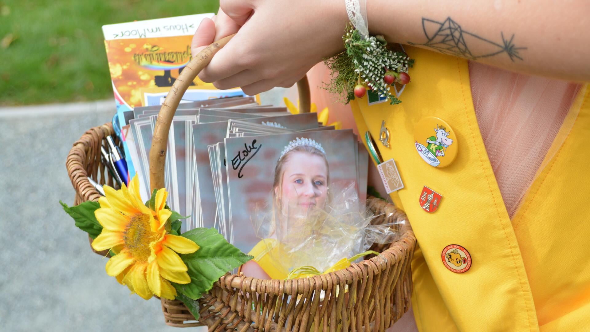 Eine Person hält einen Korb mit Autogrammkarten