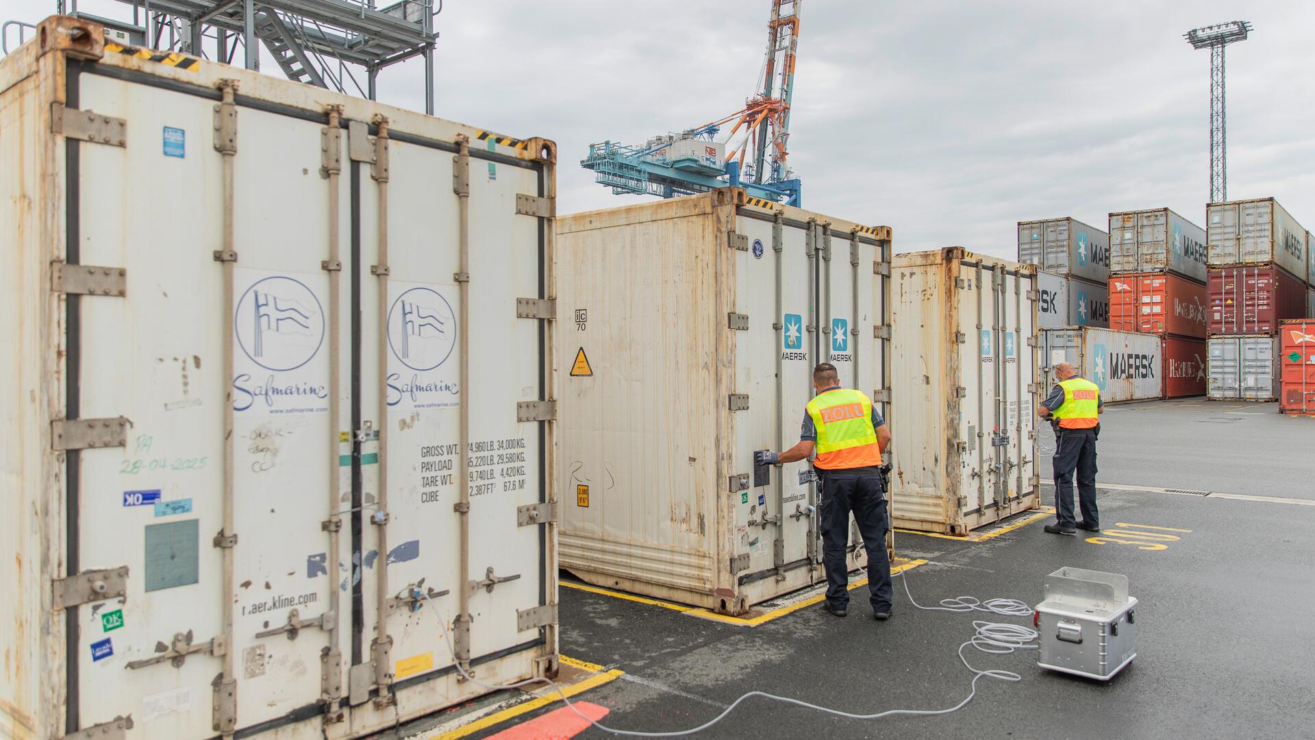 Zwei Zollbeamte arbeiten an Containern am Containerterminal in Bremerhaven.